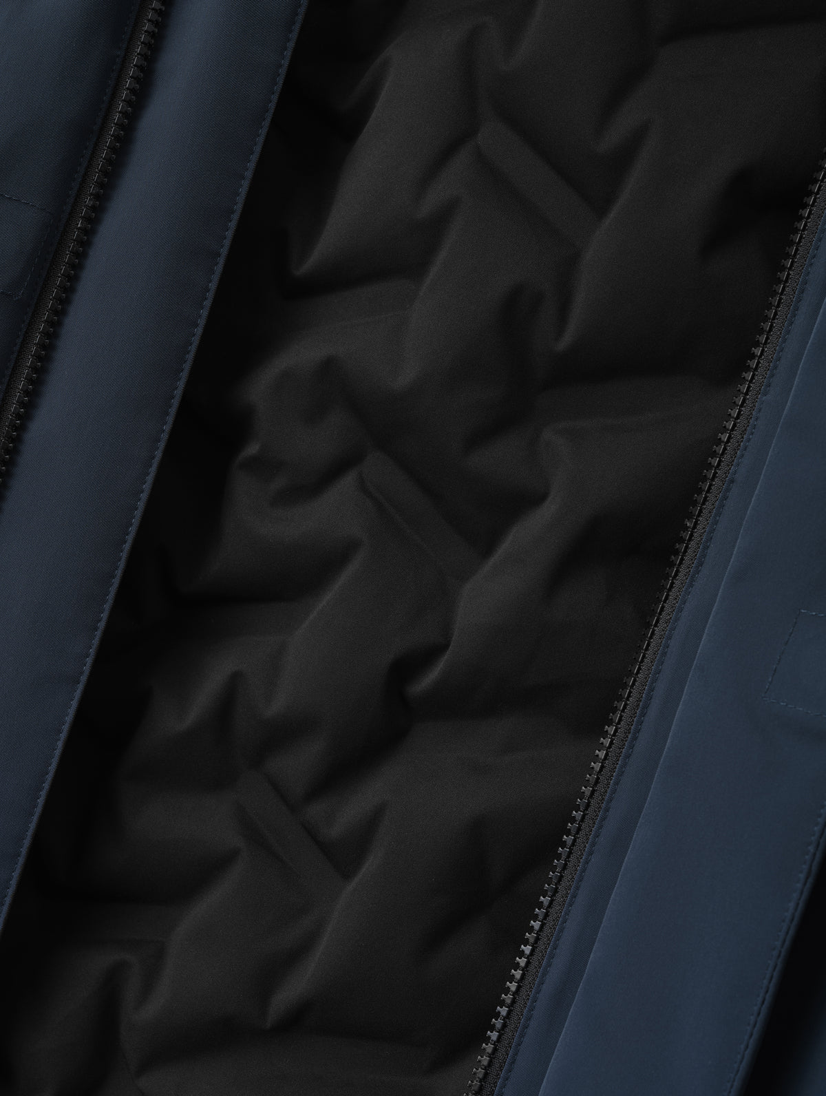 Closeup detailed view of the custom bonded insulated baffling inside the Maxwell Insulated Trench in Total Eclipse from AETHER Apparel.