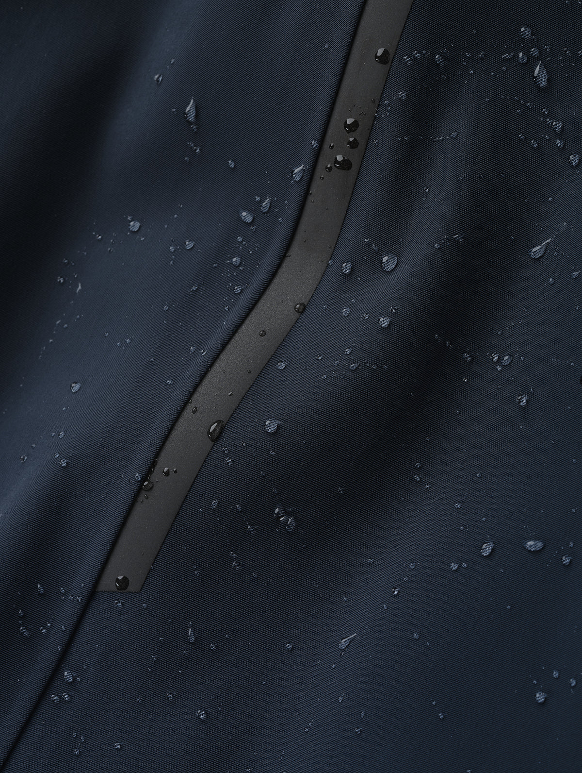 Closeup detailed view of the waterproof stretch fabric construction on the Maxwell Insulated Trench in Total Eclipse from AETHER Apparel.