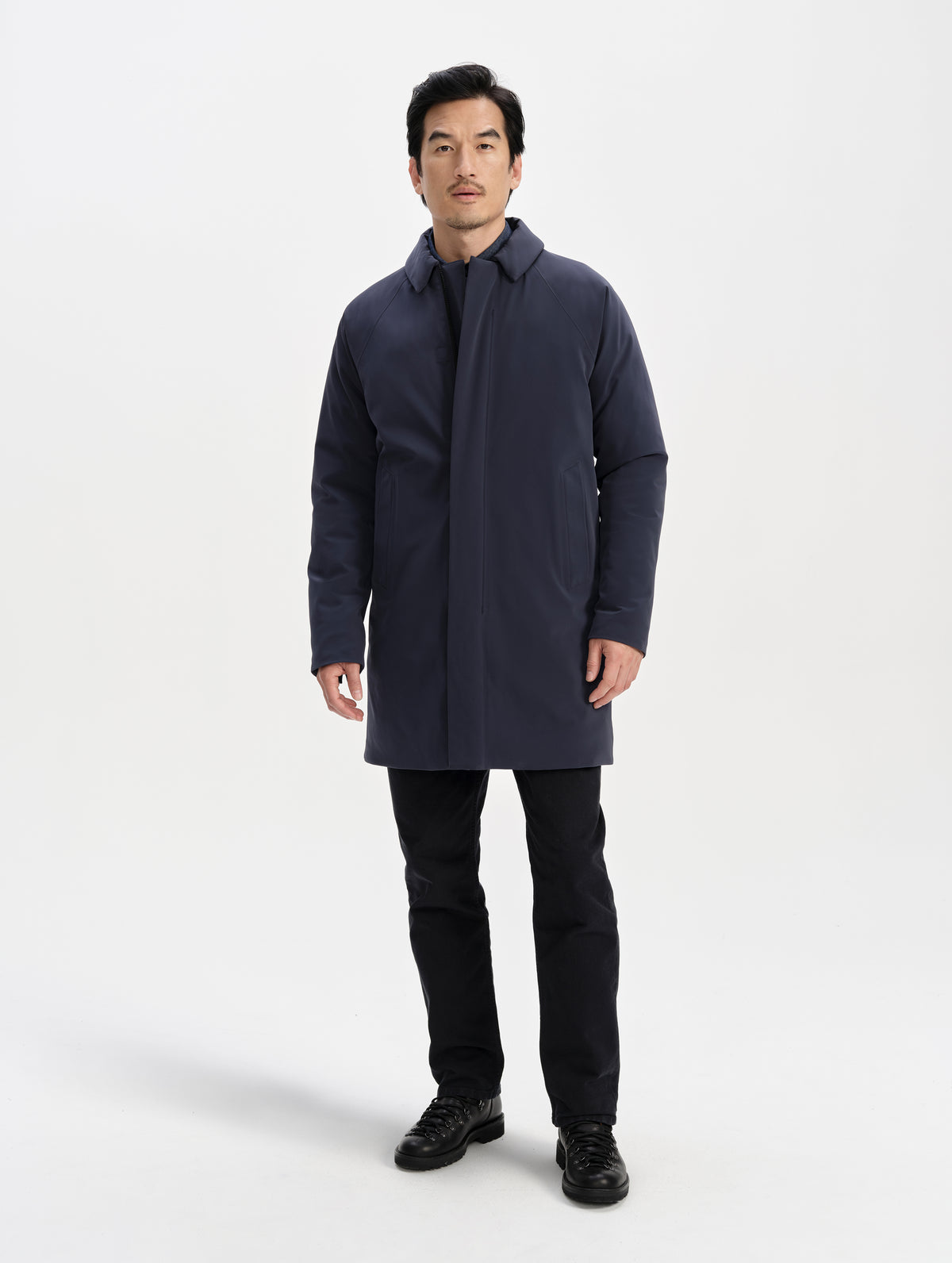 Front full-body view of man wearing the Maxwell Insulated Trench in Total Eclipse from AETHER Apparel zipped up. 