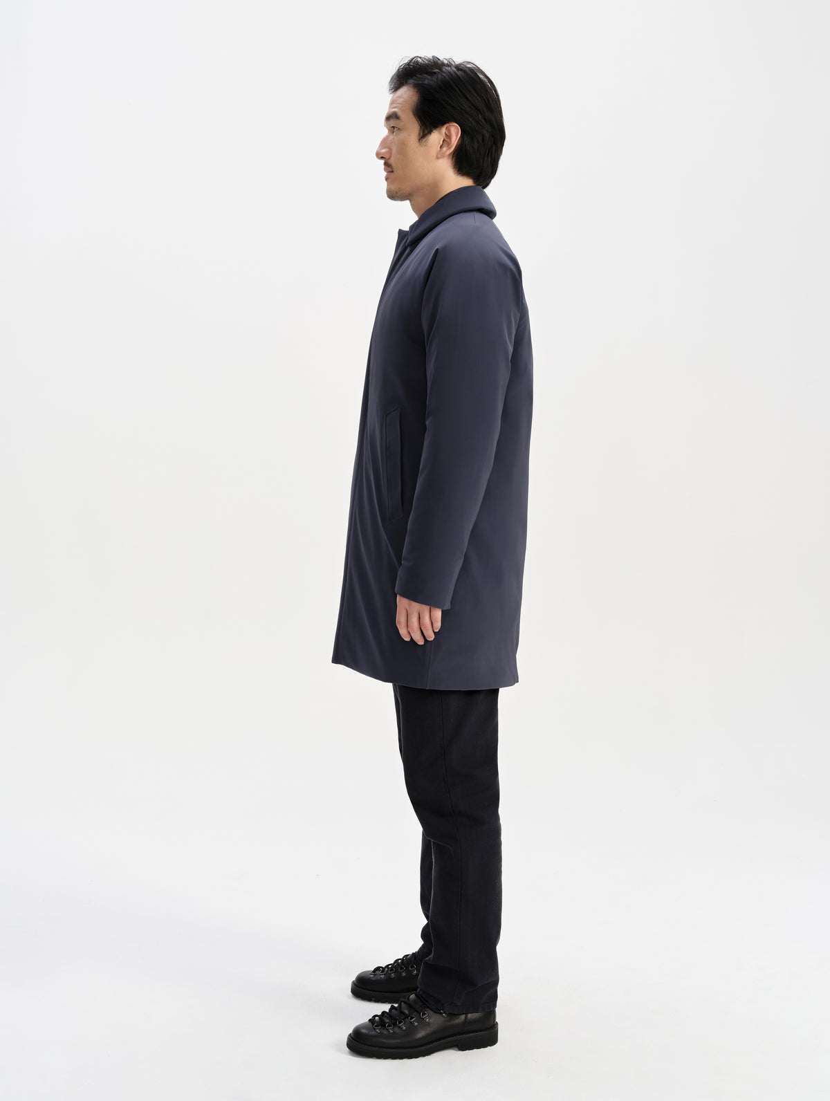 Side profile full-body view of man wearing the Maxwell Insulated Trench in Total Eclipse from AETHER Apparel.