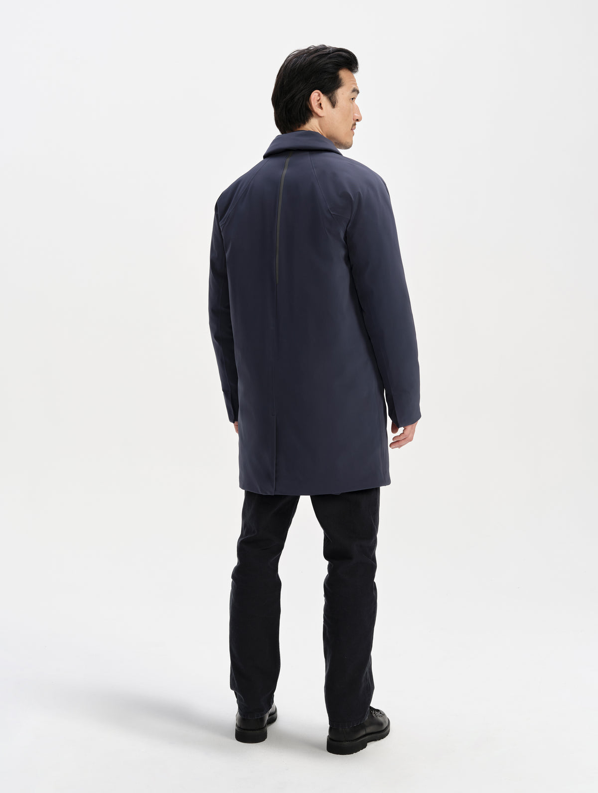 Rear full-body view of man wearing the Maxwell Insulated Trench in Total Eclipse from AETHER Apparel.