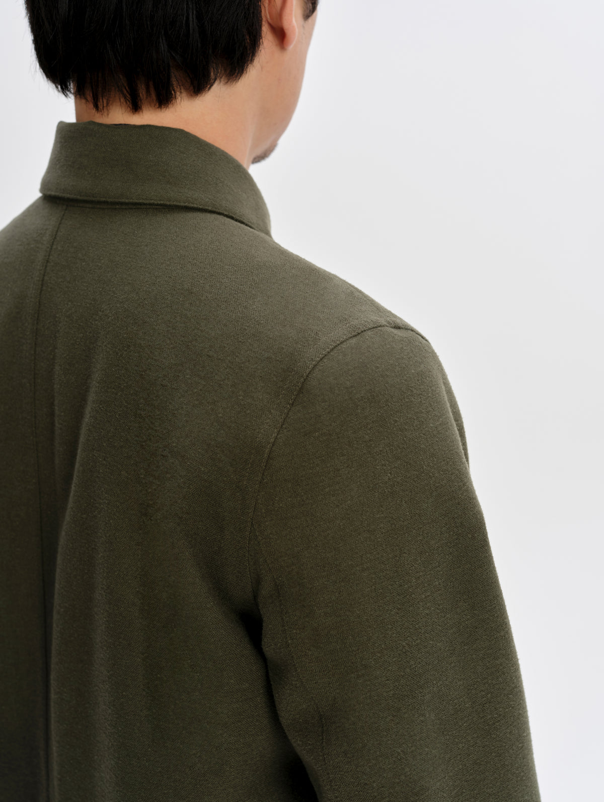 Closeup detailed view of the shoulder seams on the Milton Chore Jacket in Forest Green from AETHER Apparel. 