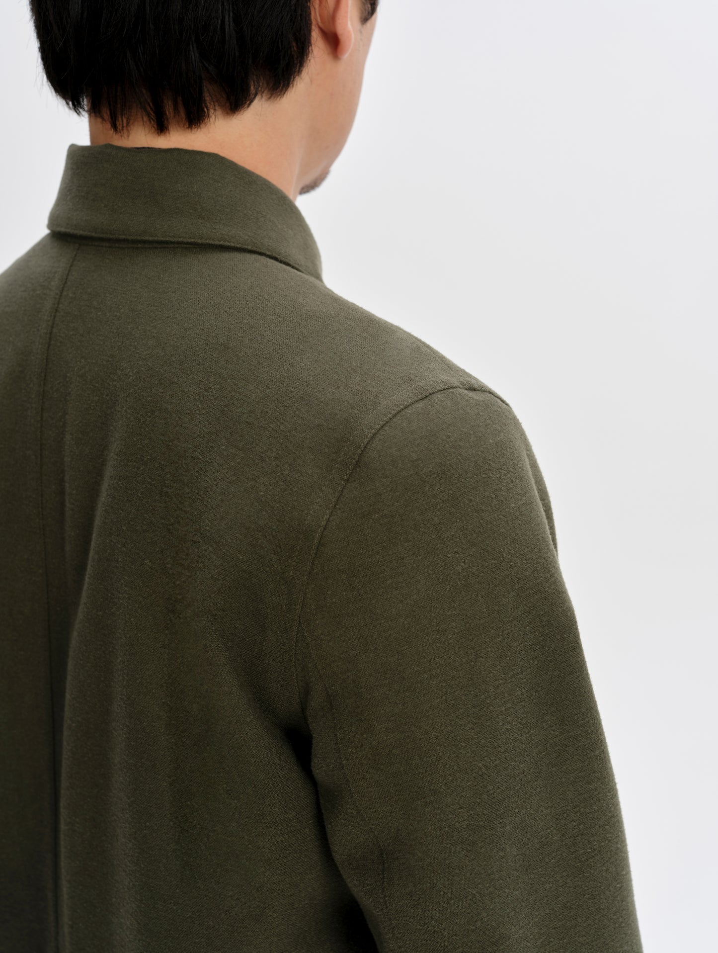 Closeup detailed view of the shoulder seams on the Milton Chore Jacket in Forest Green from AETHER Apparel. 