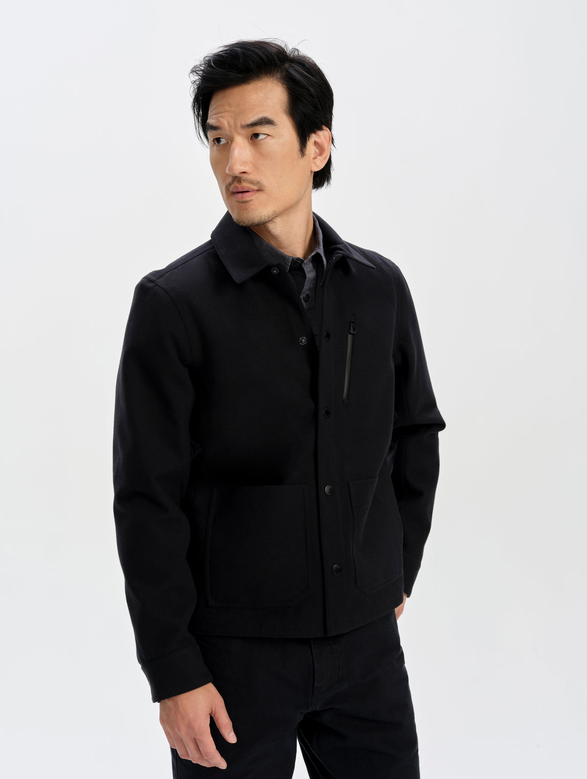 Front upper-body view of man wearing the Milton Chore Jacket in Onyx Black from AETHER Apparel. 