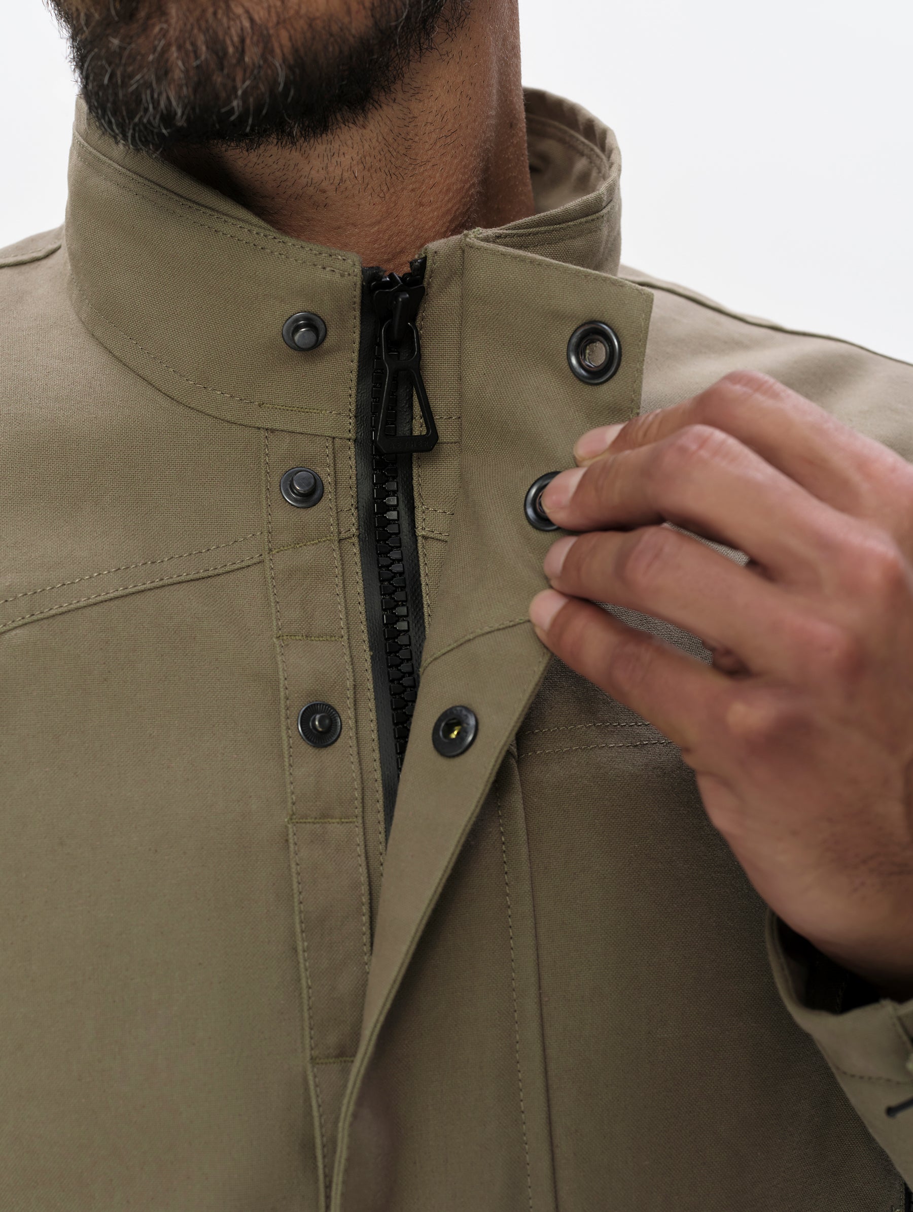 Closeup detailed view of the donut snaps, center-front zipper, and collar on the Mojave Motorcycle Jacket 2.0 in Stone Brown from AETHER Apparel.