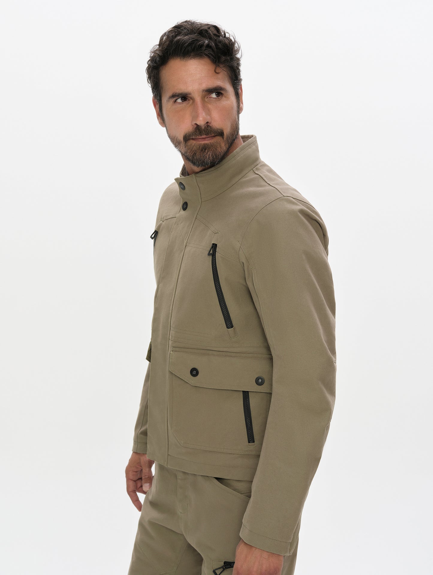 Side profile, upper-body view of man wearing the Mojave Motorcycle Jacket 2.0 in Stone Brown from AETHER Apparel.