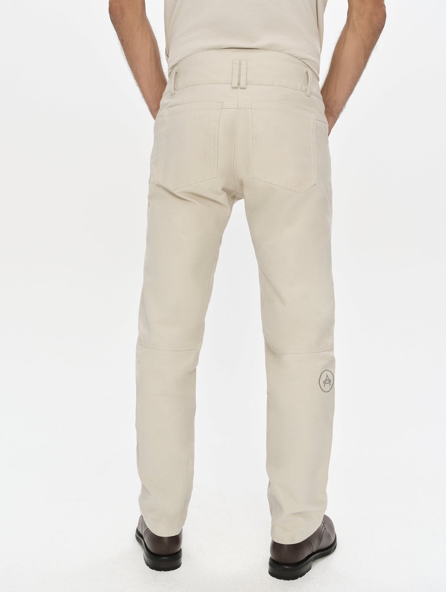 Rear lower-body view of man wearing the Mojave Motorcycle Pant 2.0 in Bone from AETHER Apparel.