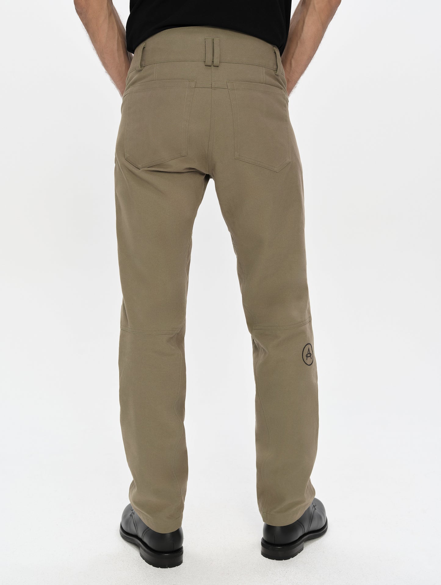 Rear, lower-body view of man wearing the Mojave Motorcycle Pant 2.0 in Stone Brown from AETHER Apparel.
