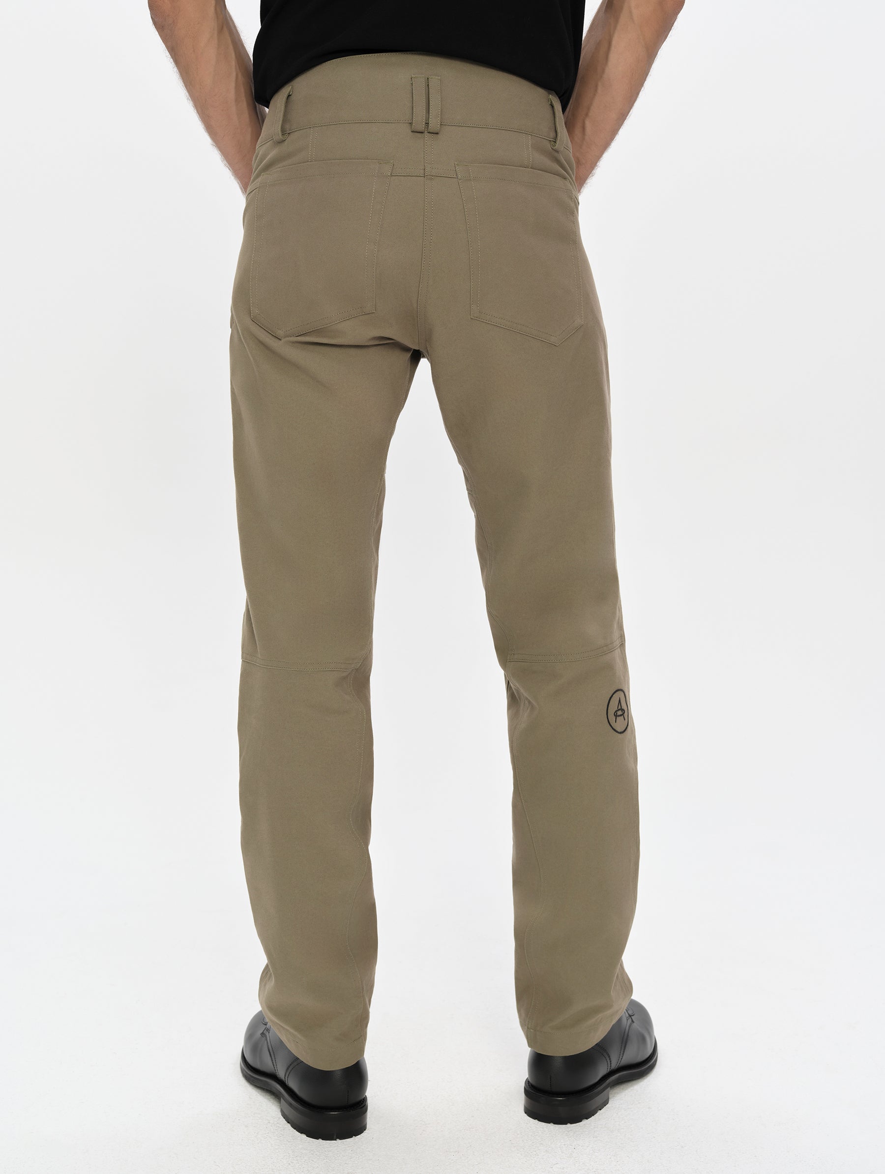 Rear, lower-body view of man wearing the Mojave Motorcycle Pant 2.0 in Stone Brown from AETHER Apparel.