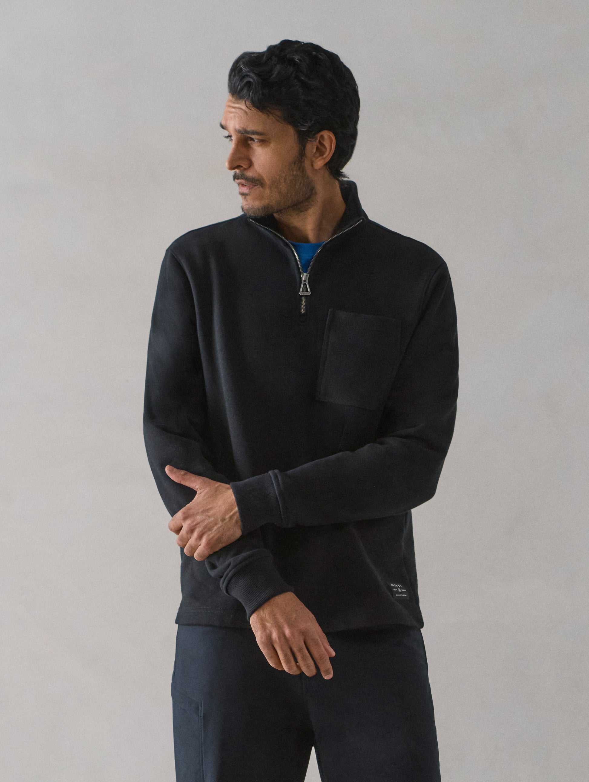 Front body view of man wearing Monte Half-Zip Sweatshirt in Onyx Black from AETHER Apparel.