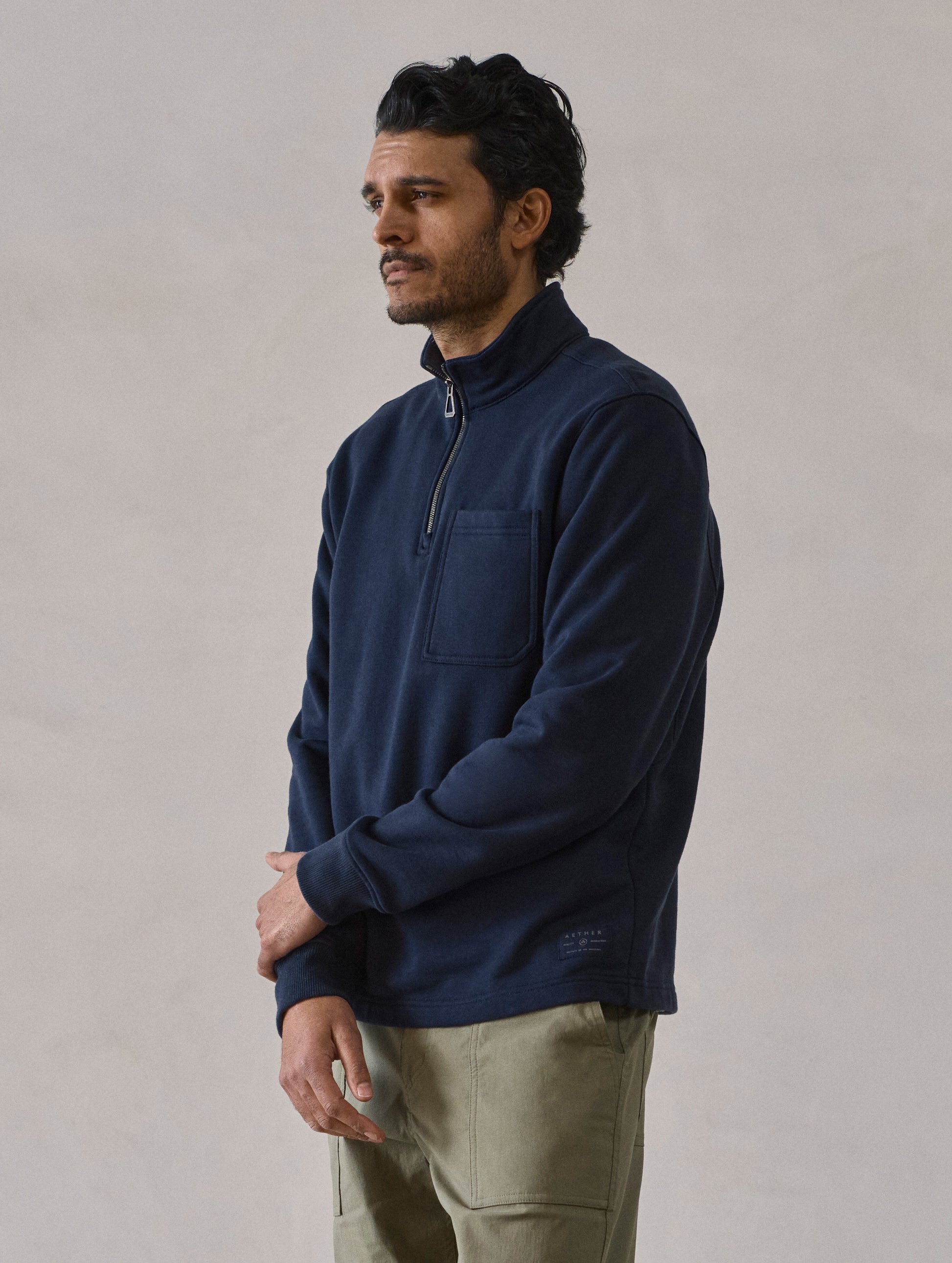 Front 3/4 body view of man wearing Monte Half-Zip Sweatshirt in Total Eclipse dark blue from AETHER Apparel.