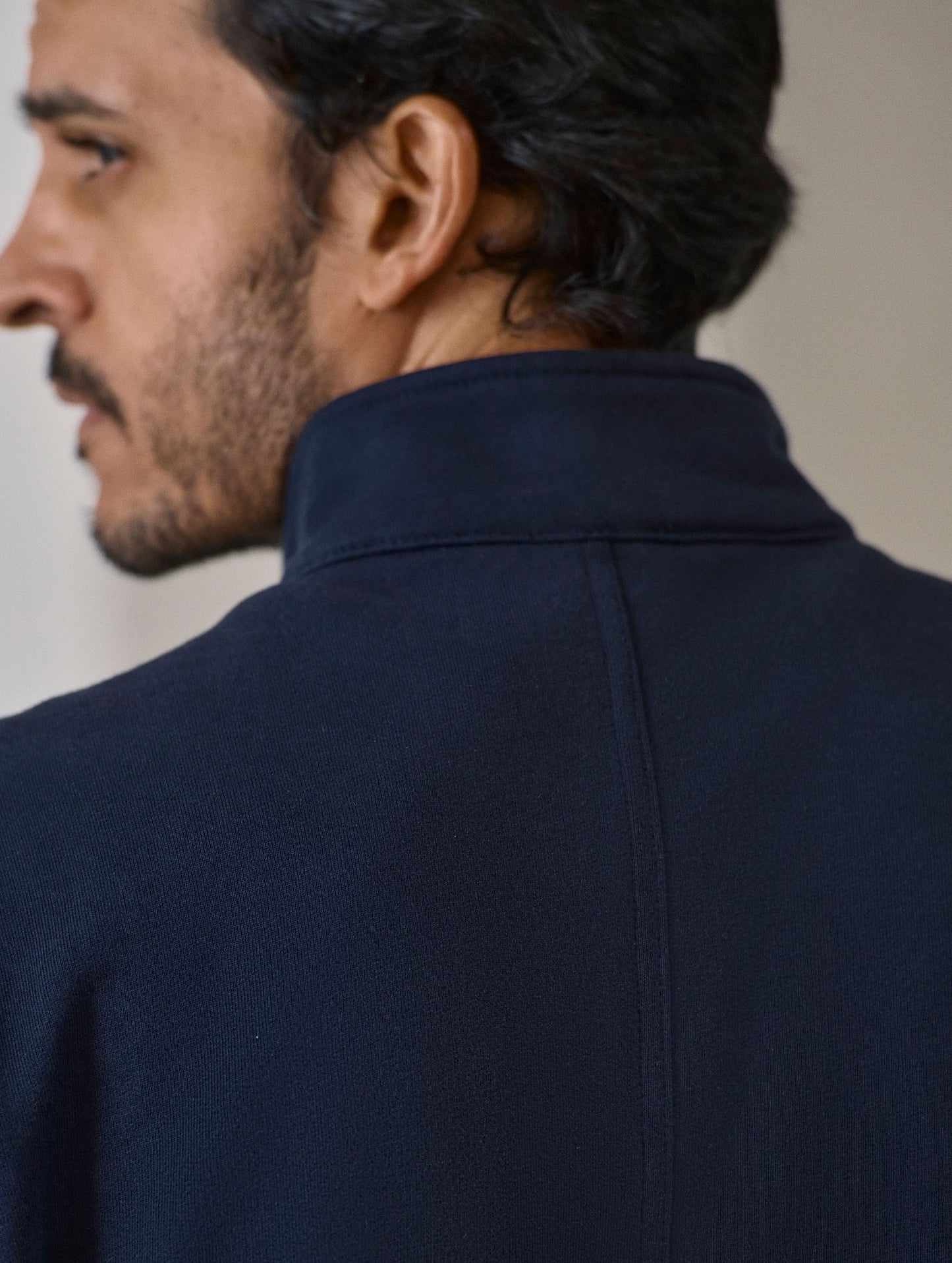 Closeup detailed view of the center-back seam and collar on the Monte Half-Zip Sweatshirt in Total Eclipse dark blue from AETHER Apparel.