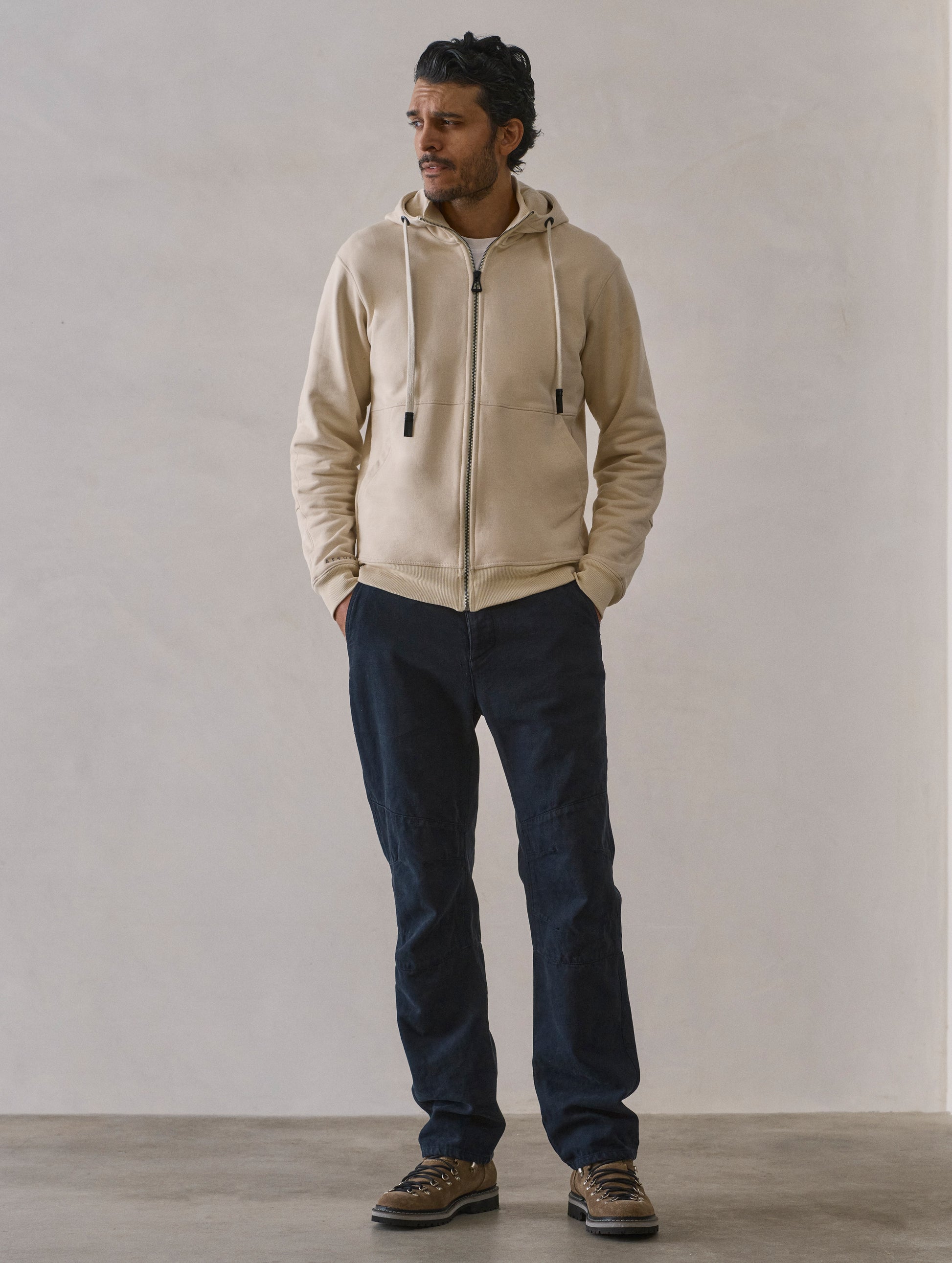 Front full-body view of man wearing Monte Full-Zip Hoodie in Bone white from AETHER Apparel.