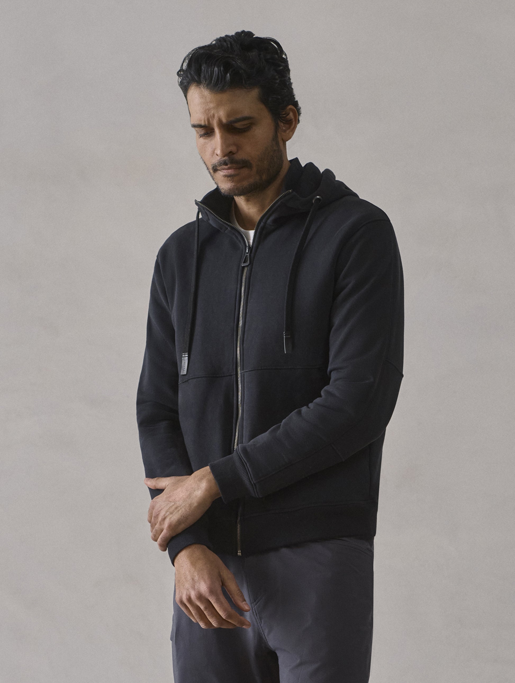 Front 3/4 upper-body view of man wearing Monte Full-Zip Hoodie in Onyx Black from AETHER Apparel.