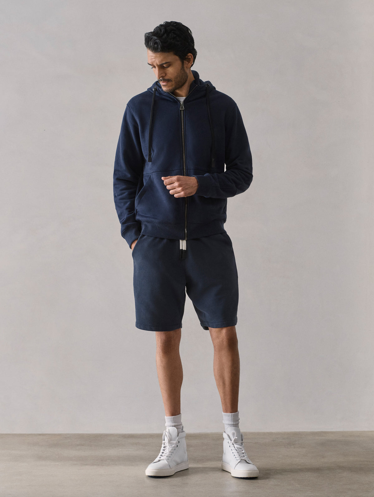 Front full-body view of man wearing Monte Full-Zip Hoodie in Total Eclipse dark blue from AETHER Apparel.