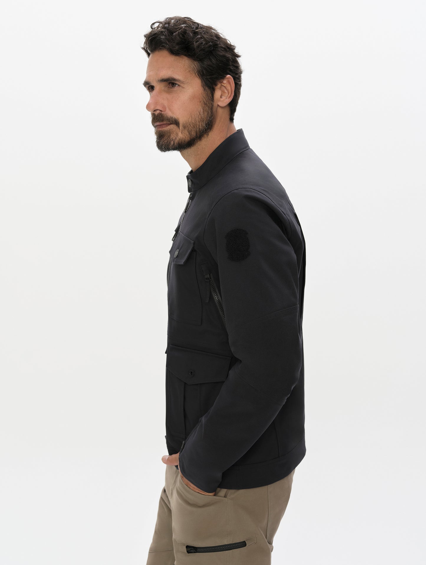 Side, profile, upper-body view of man wearing the Mulholland Motorcycle Jacket Special Edition in Onyx Black from AETHER Apparel.