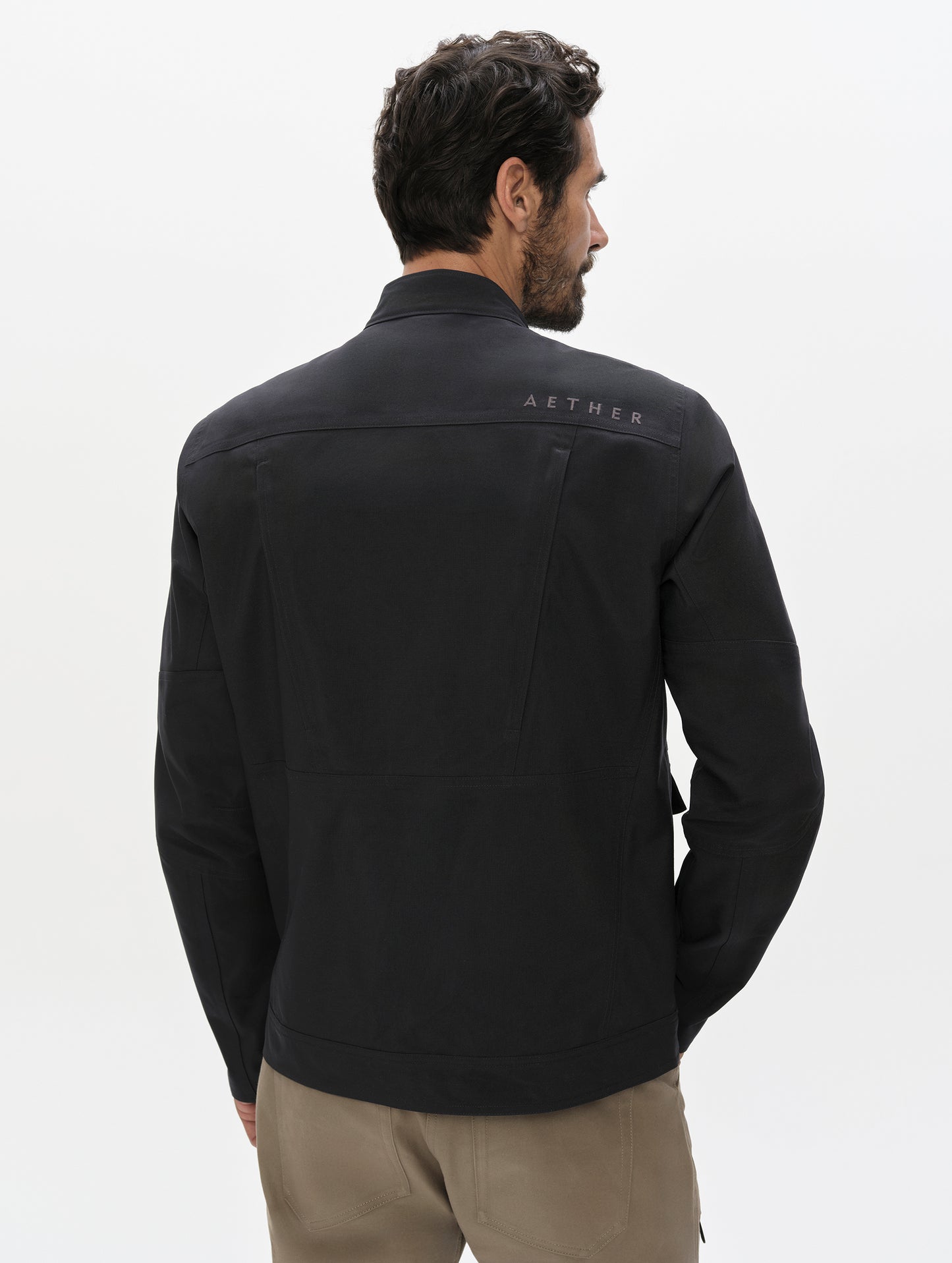 Rear, upper-body view of man wearing the Mulholland Motorcycle Jacket Special Edition in Onyx Black from AETHER Apparel.