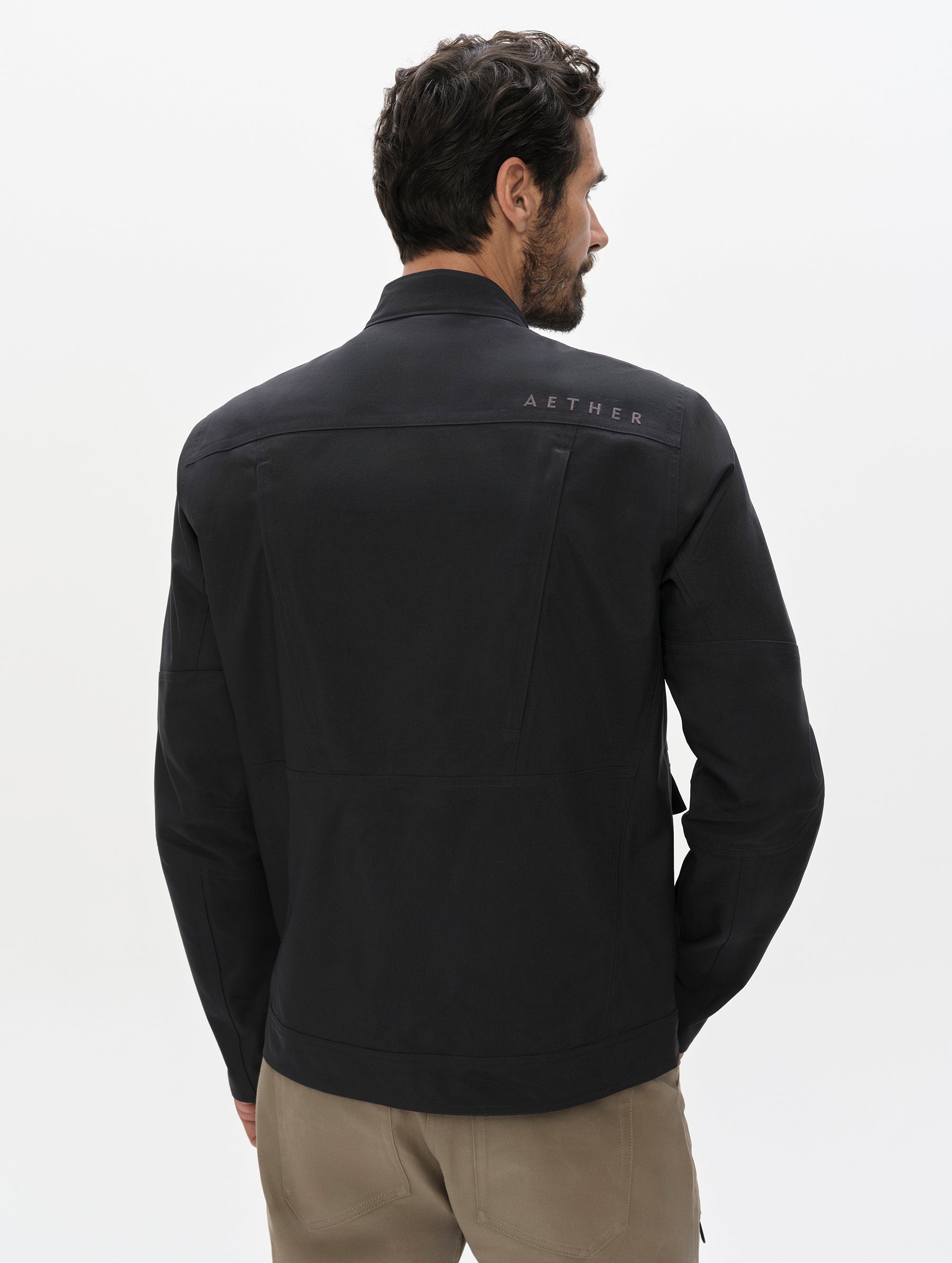 Rear, upper-body view of man wearing the Mulholland Motorcycle Jacket Special Edition in Onyx Black from AETHER Apparel.