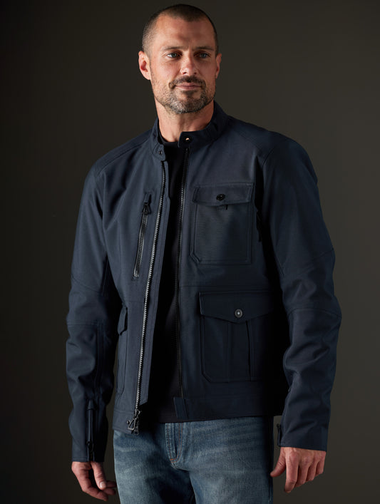 Front 3/4 body view of man wearing Mulholland Motorcycle Jacket in Total Eclipse dark blue from AETHER Apparel.