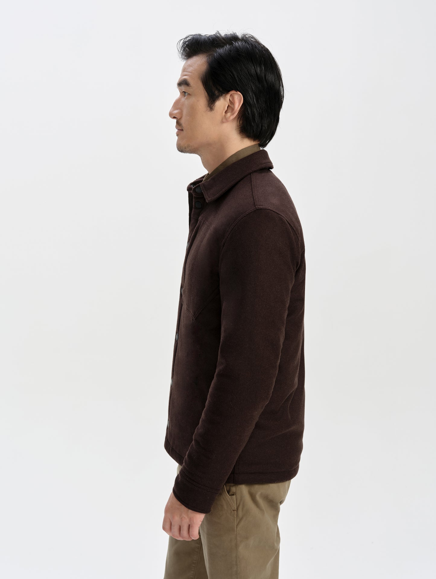 Side profile upper-body view of man wearing the Nova Insulated Button-Down in Ash Brown from AETHER Apparel.