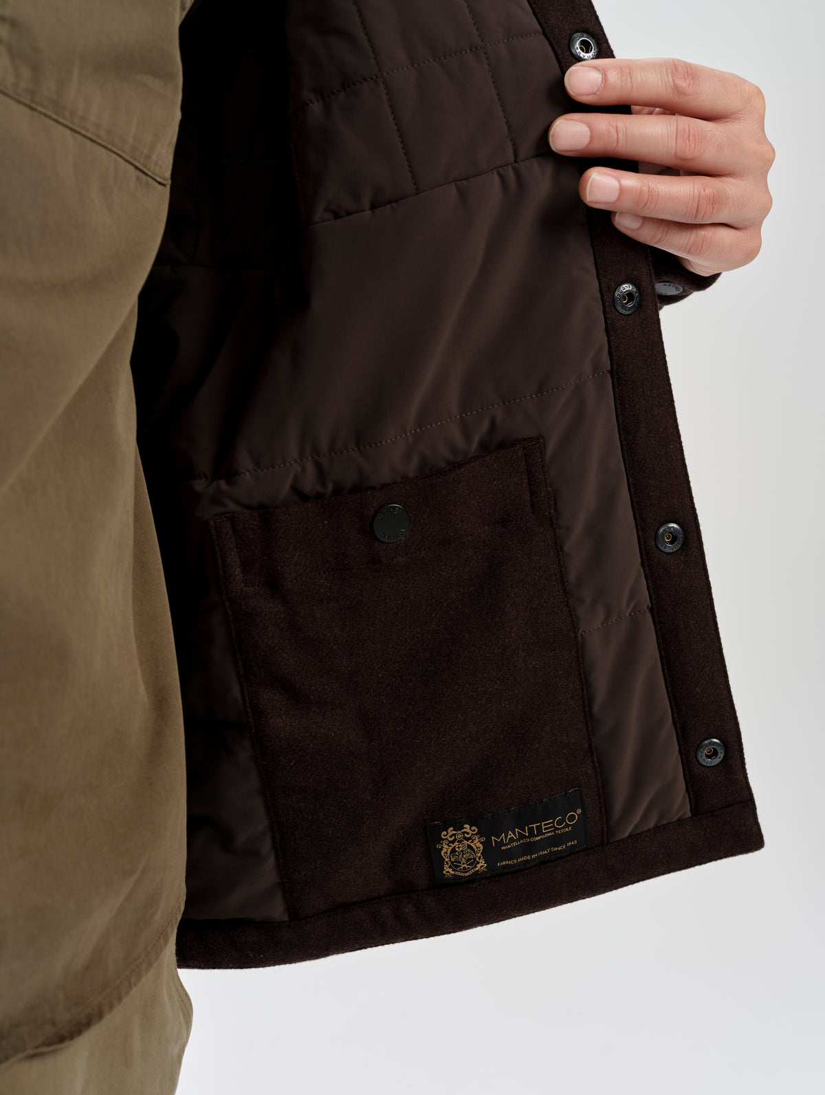 Closeup detailed view of the interior lining, interior drop pocket, and Manteco label on the Nova Insulated Button-Down in Ash Brown from AETHER Apparel.