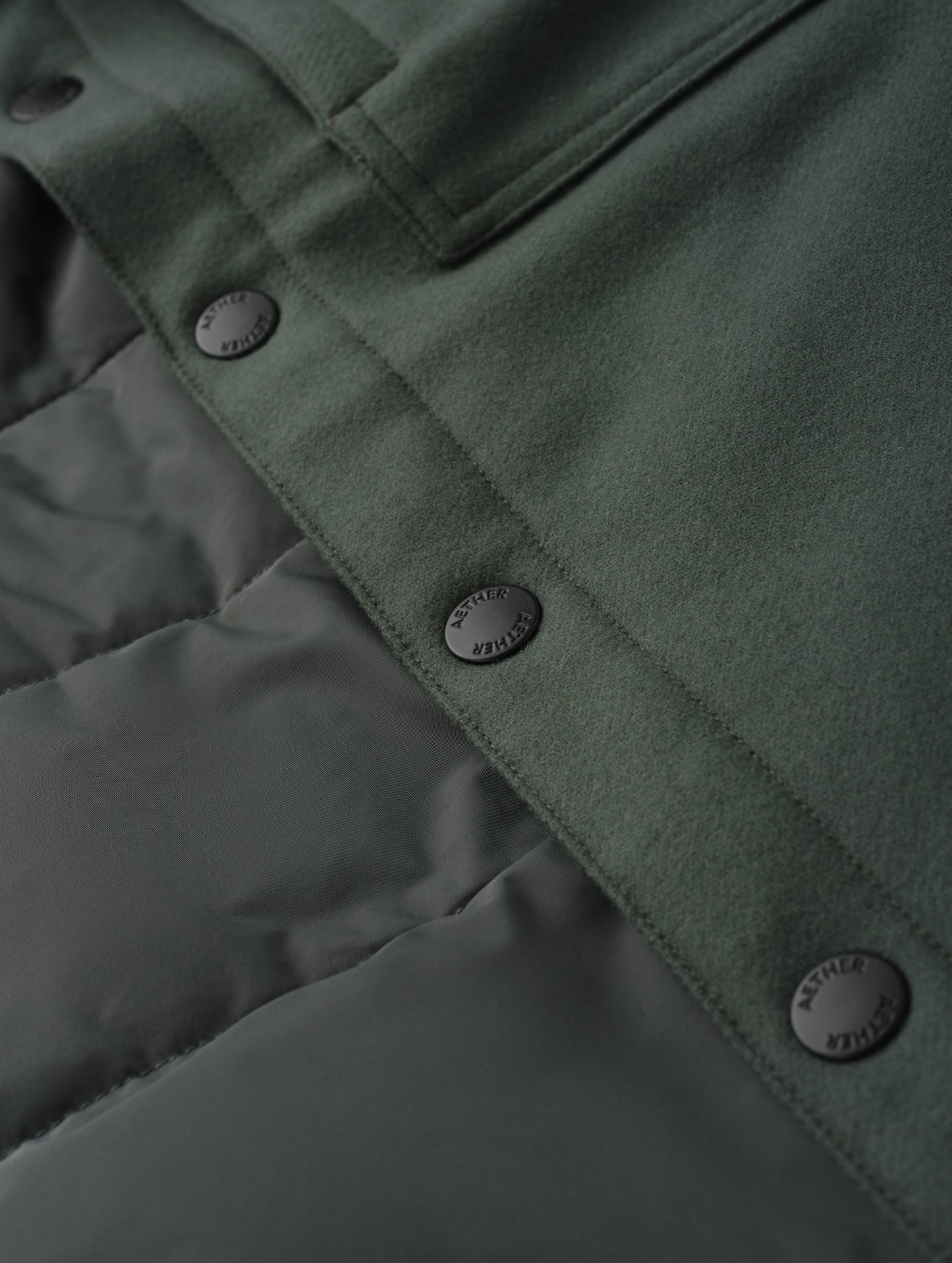 Closeup detailed view of the snap buttons and interior lining on Nova Insulated Button-Down in Saville Green from AETHER Apparel.