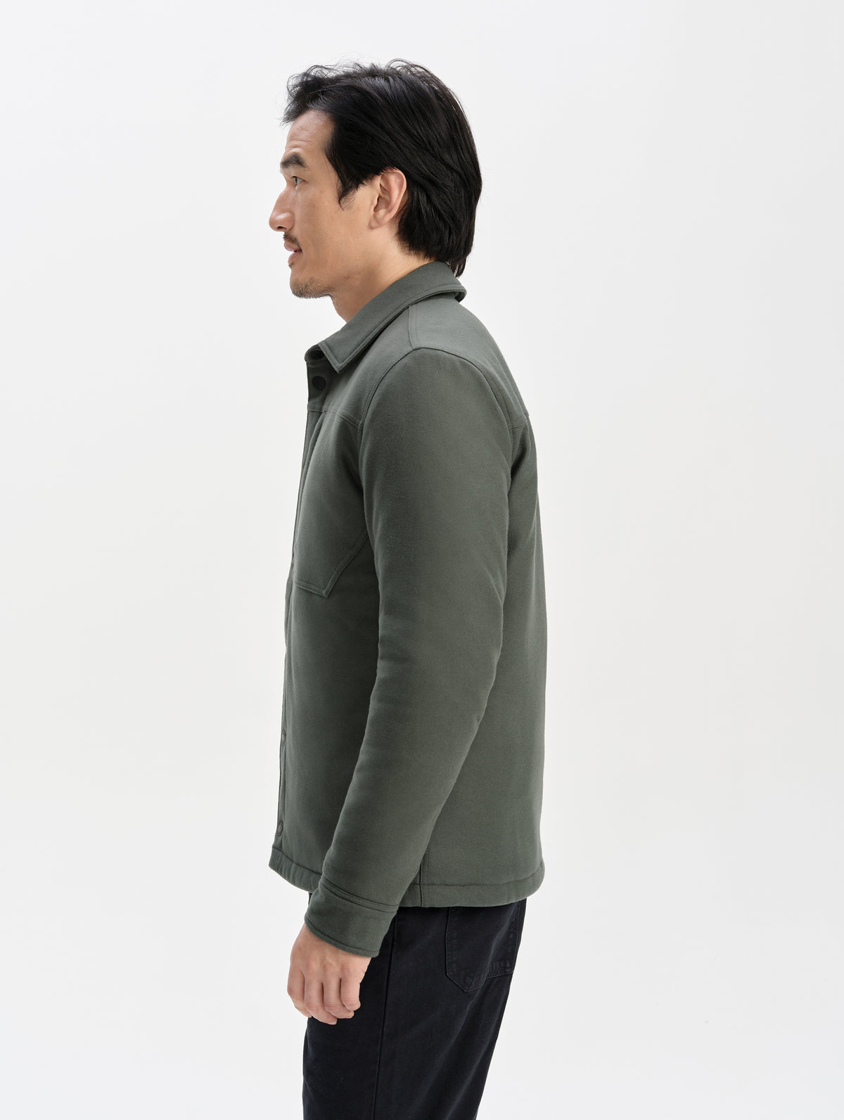 Side profile upper-body view of man wearing the Nova Insulated Button-Down in Saville Green from AETHER Apparel.