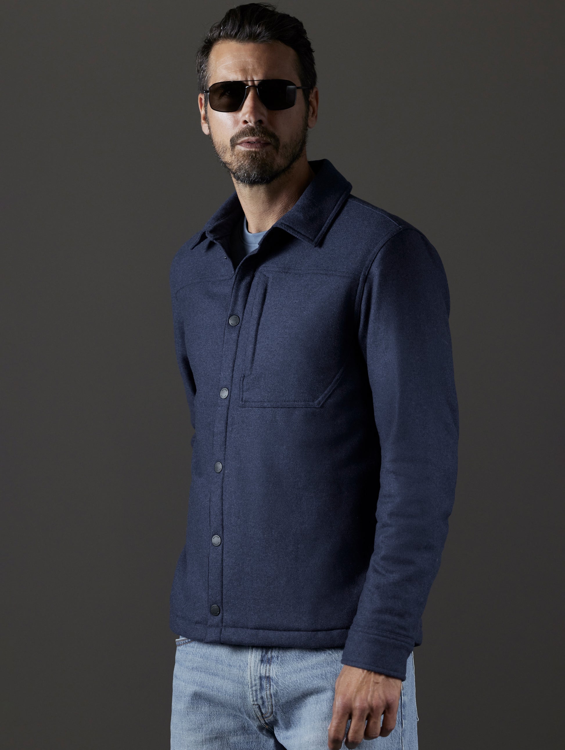 Front 3/4 body view of man wearing Nova Insulated Button-Down in Total Eclipse Heather dark blue from AETHER Apparel.