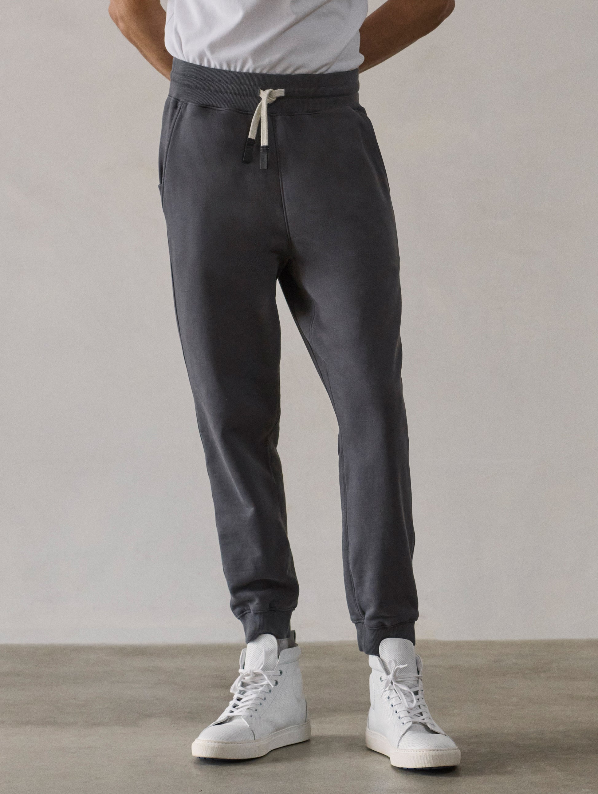 Front lower-body view of man wearing Osa Cuffed Sweatpant in Graphite grey from AETHER Apparel.