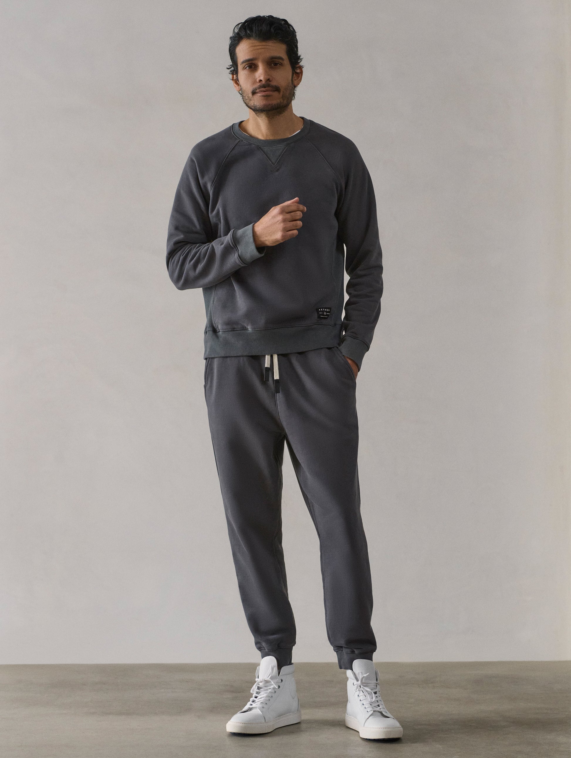 Front full-body view of man wearing Osa Cuffed Sweatpant in Graphite grey from AETHER Apparel.