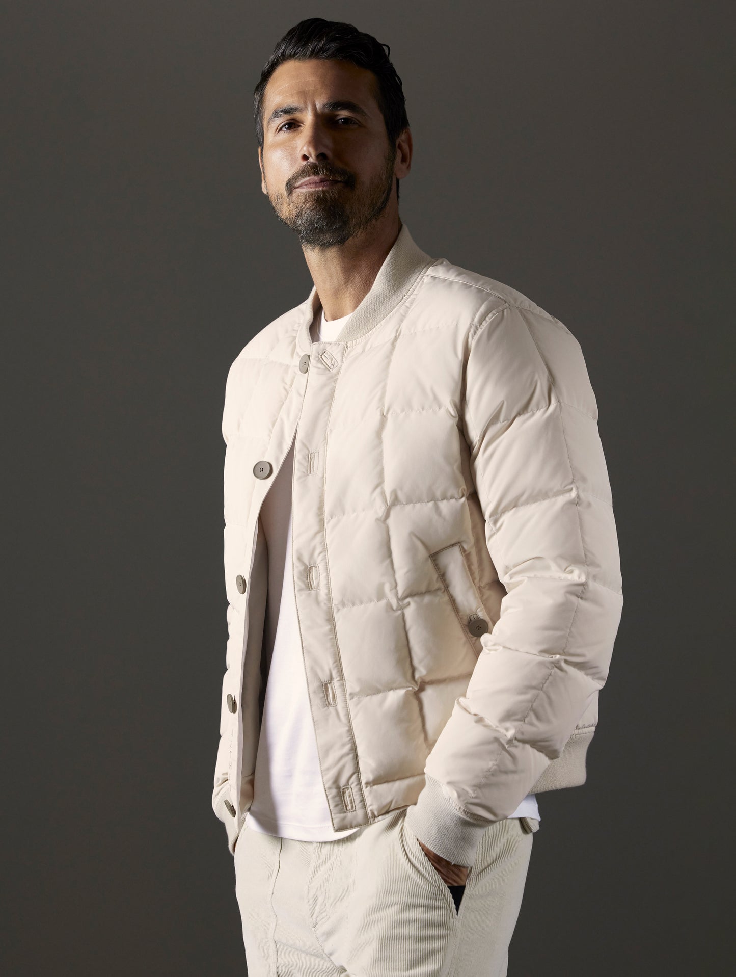 Front body view of man wearing Pacer Jacket in Bone white from AETHER Apparel.