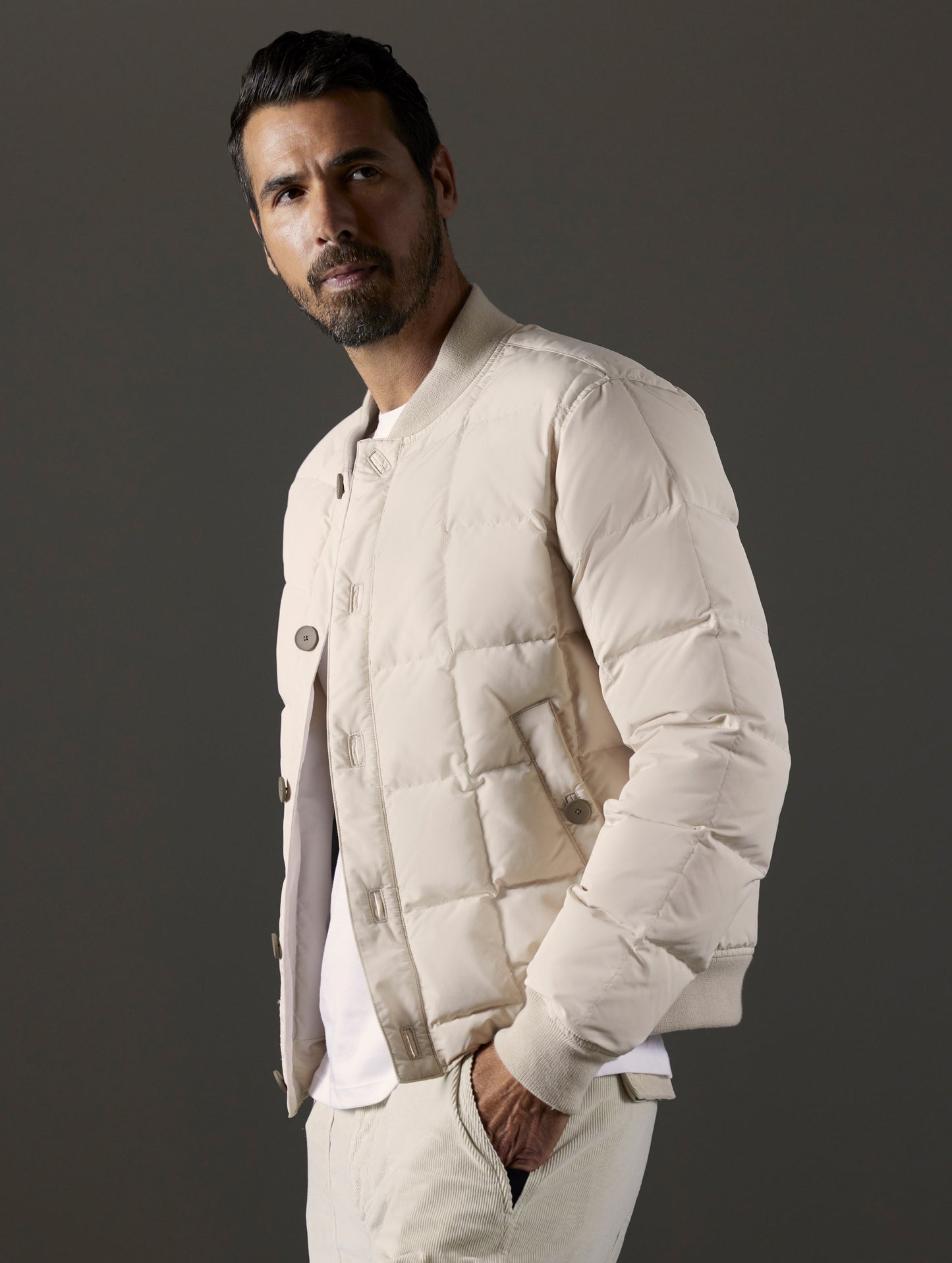 Front 3/4 body view of man wearing Pacer Jacket in Bone white from AETHER Apparel.