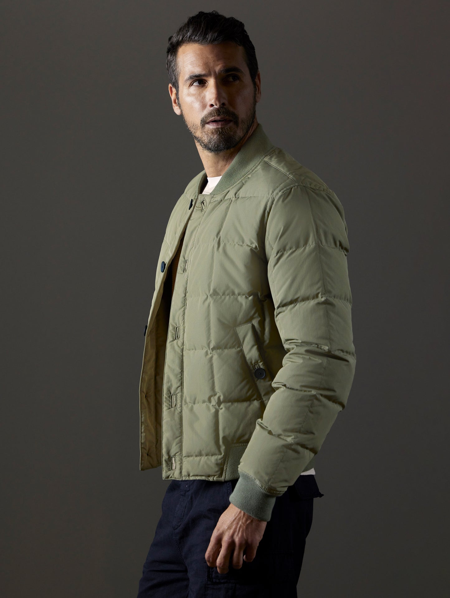 Side profile body view of man wearing Pacer Jacket in Fern Green from AETHER Apparel.