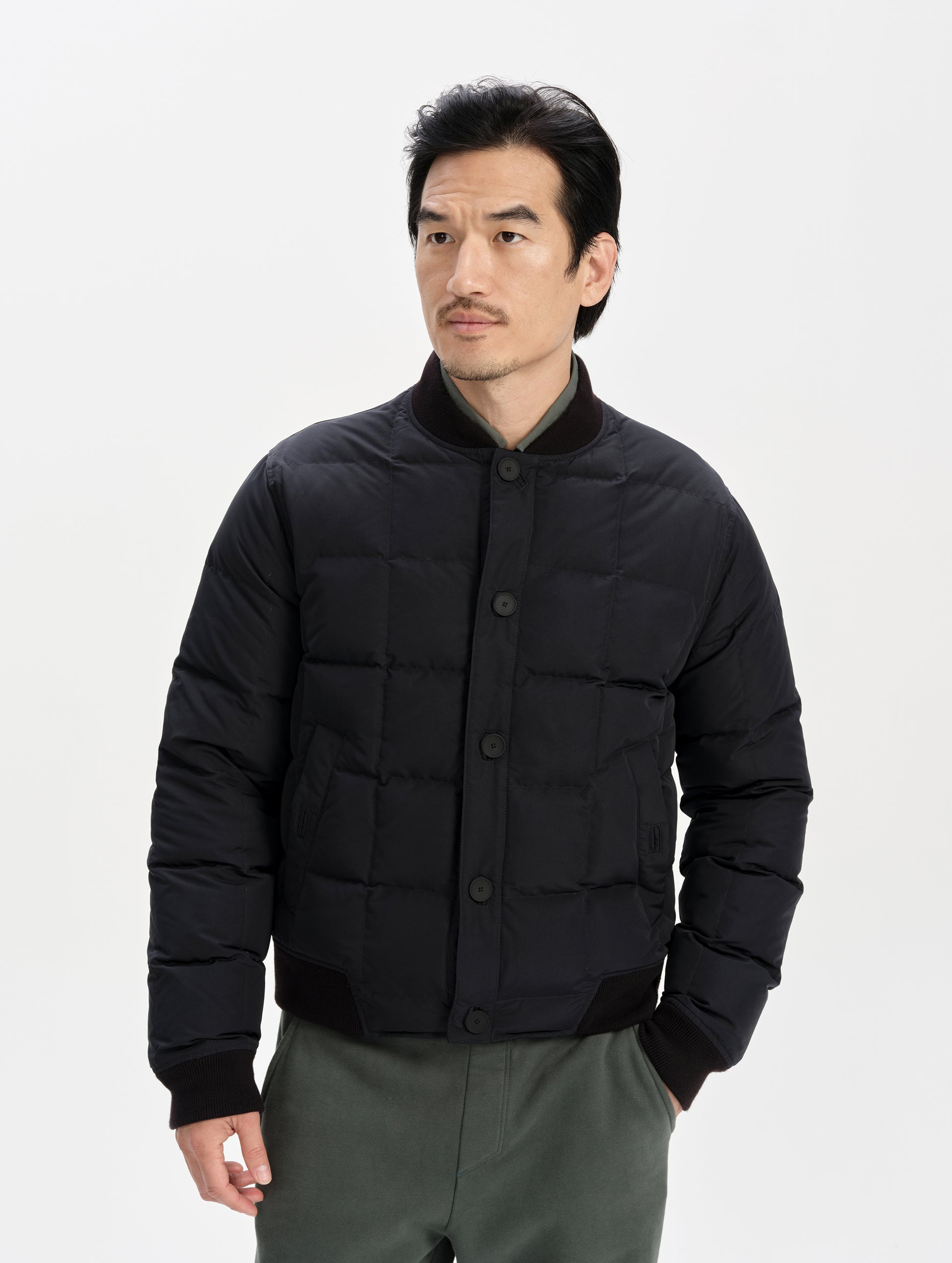 Front upper-body view of man wearing the Pacer Jacket in Onyx Black from AETHER Apparel.