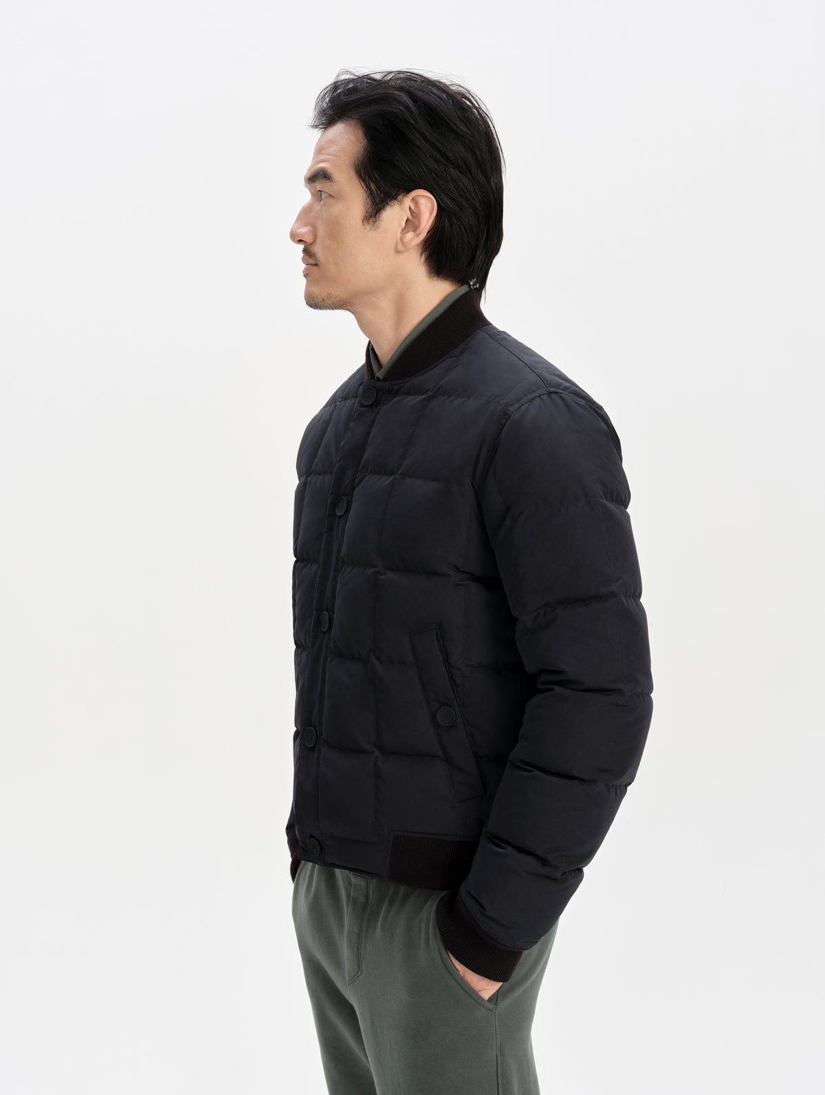 Side profile upper-body view of man wearing the Pacer Jacket in Onyx Black from AETHER Apparel.