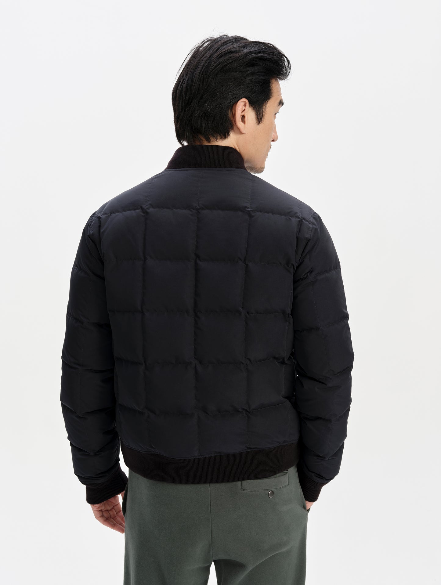 Rear upper-body view of man wearing the Pacer Jacket in Onyx Black from AETHER Apparel.