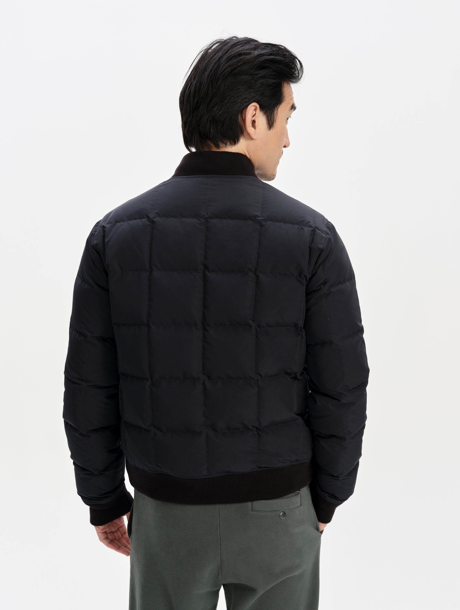 Rear upper-body view of man wearing the Pacer Jacket in Onyx Black from AETHER Apparel.