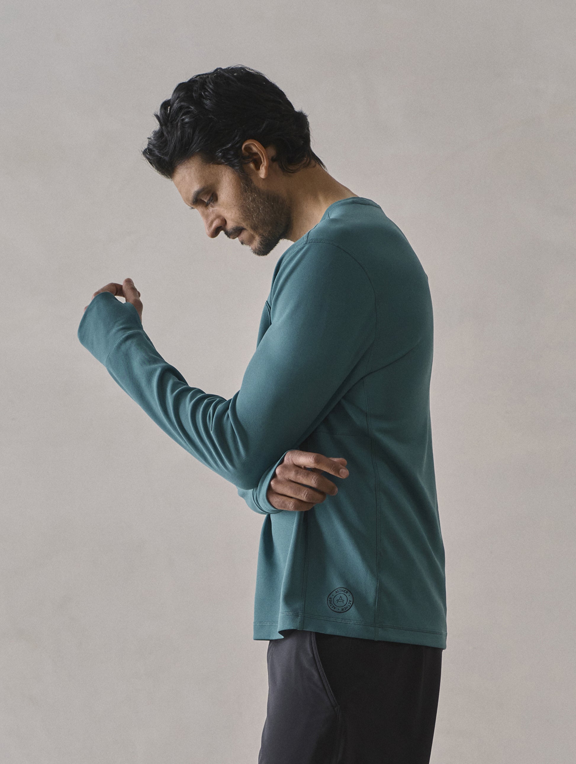 Side profile upper-body view of man wearing Pacific Crewneck Sun Shirt in Aqua Blue from AETHER Apparel.