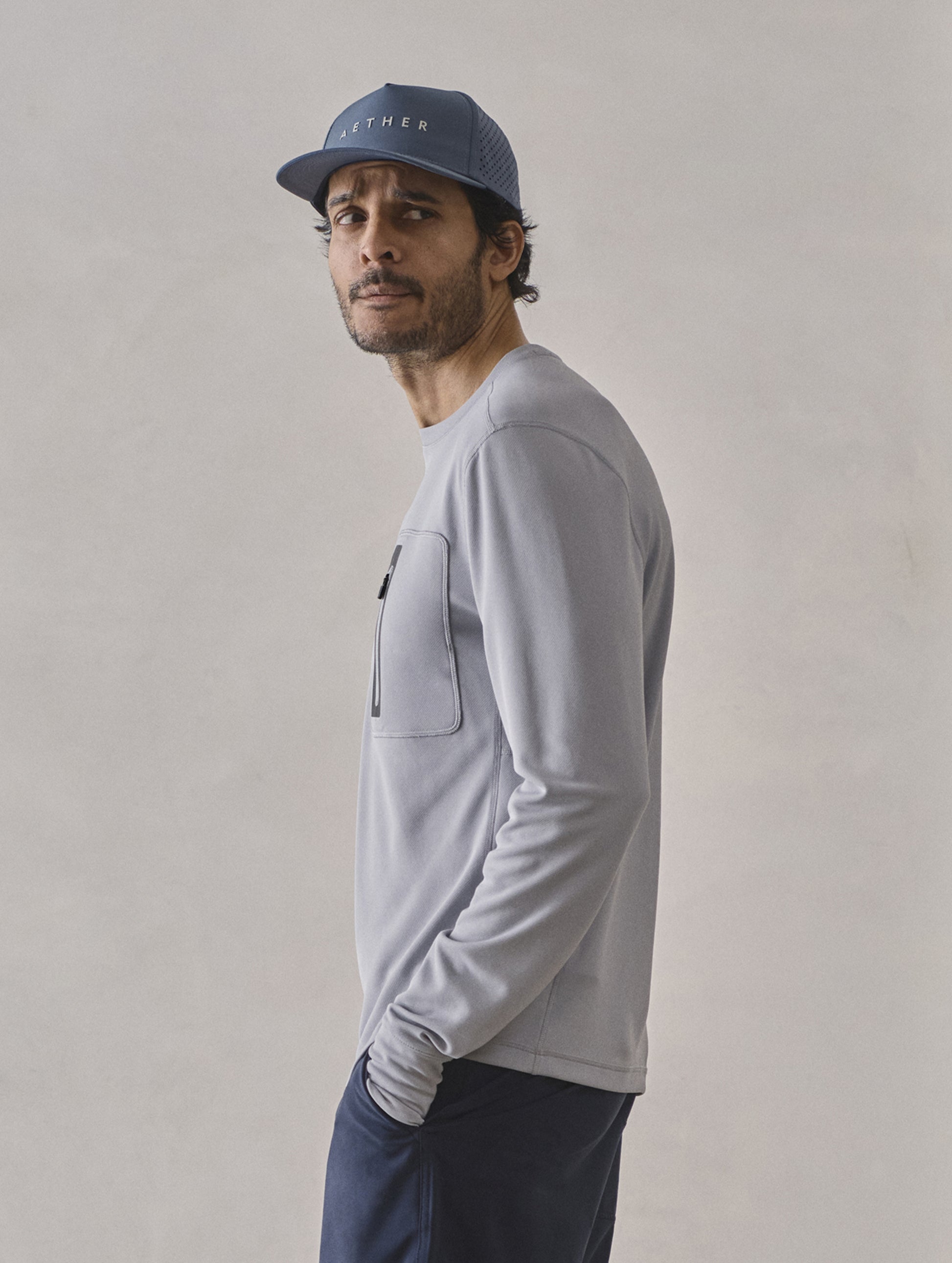 Side profile upper-body view of man wearing Pacific Crewneck Sun Shirt in Sky Grey from AETHER Apparel.