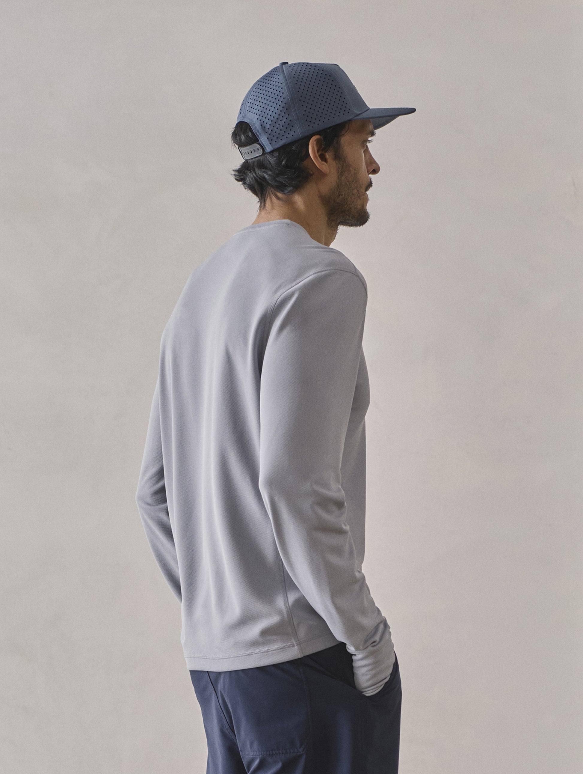 Rear 3/4 upper-body view of man wearing Pacific Crewneck Sun Shirt in Sky Grey from AETHER Apparel.