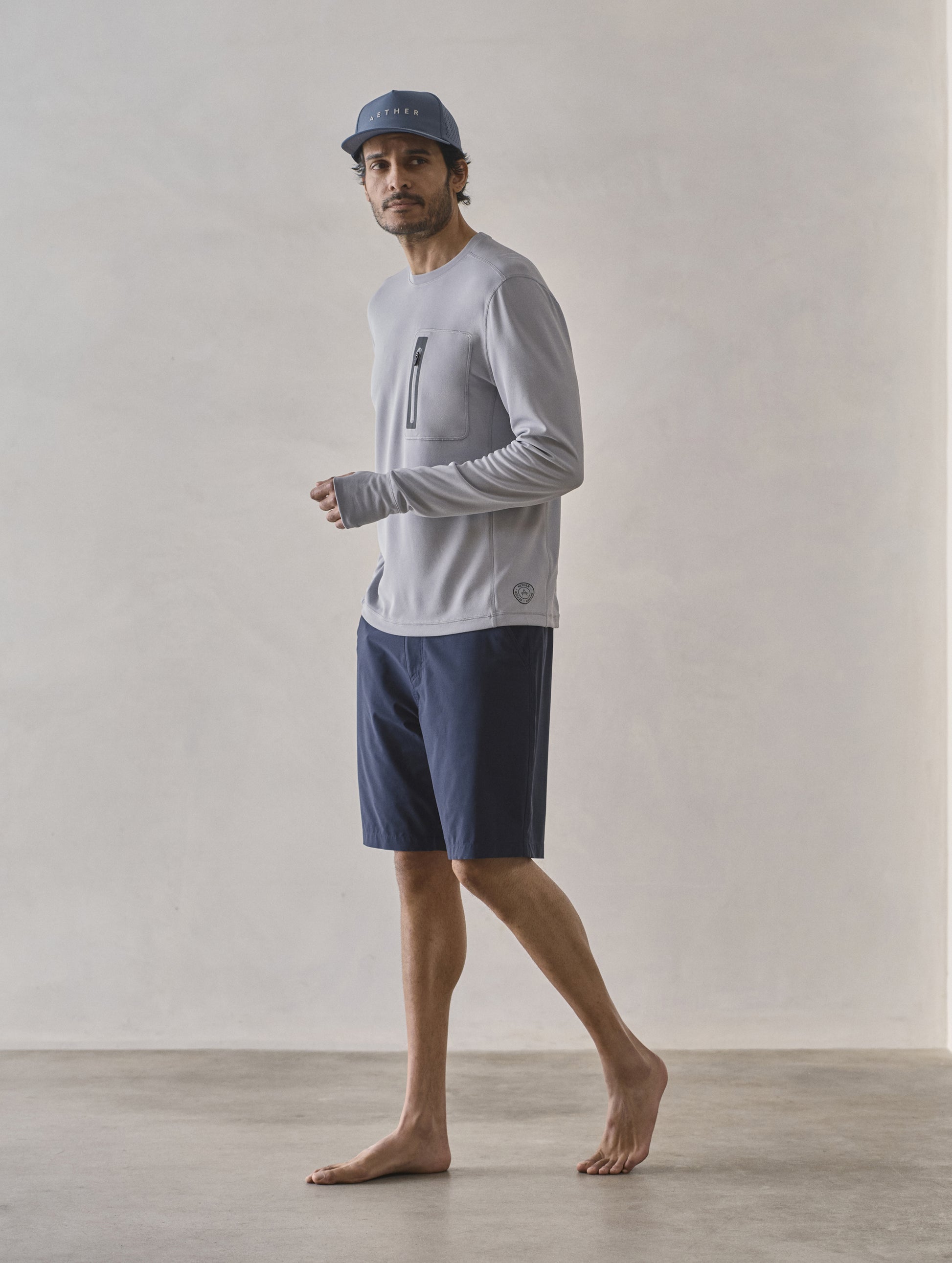 Front 3/4 full-body view of man wearing Pacific Crewneck Sun Shirt in Sky Grey from AETHER Apparel.