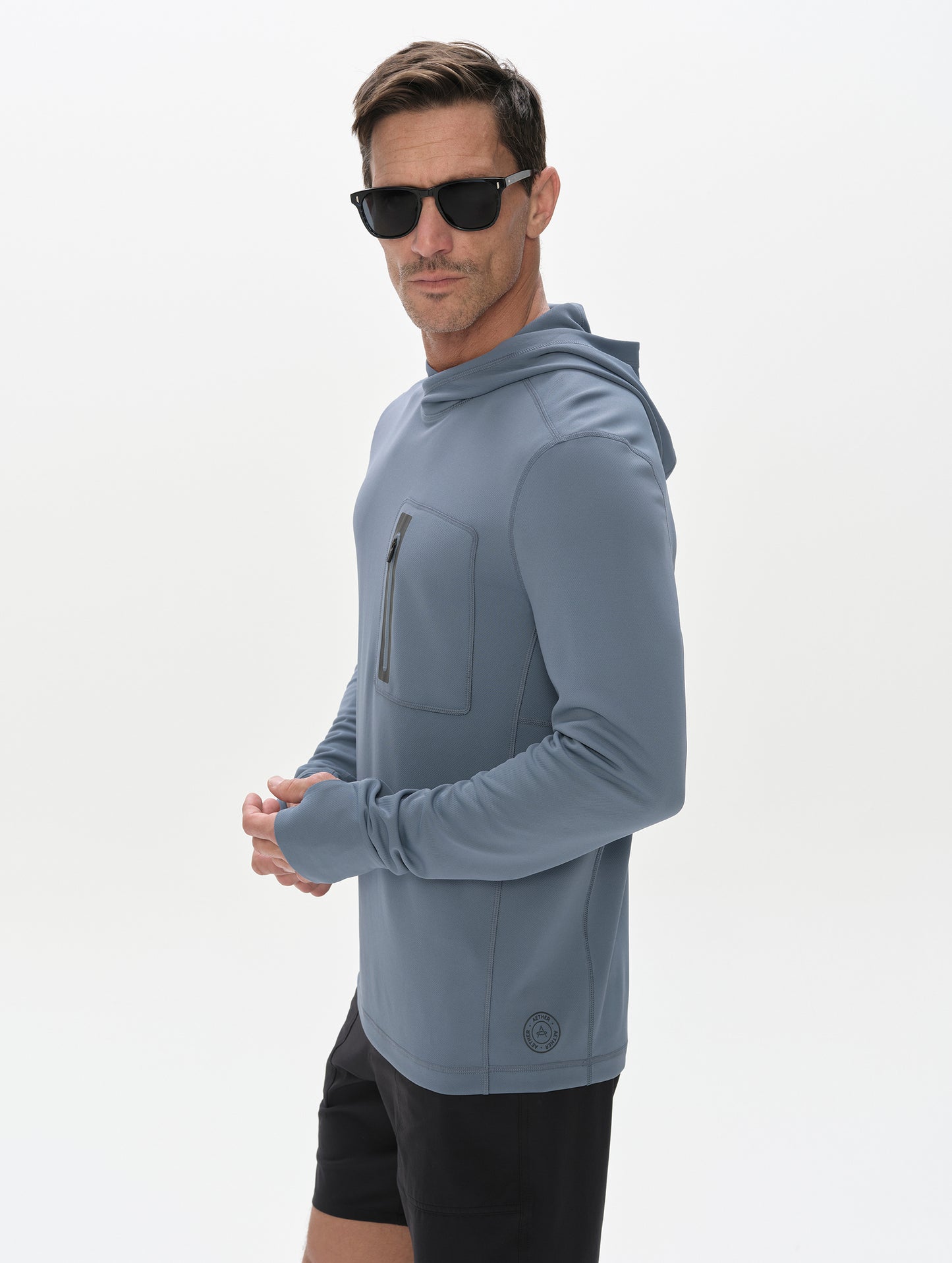 Front 3/4 upper-body view of man wearing Pacific Hooded Sun Shirt in Portal Blue from AETHER Apparel.