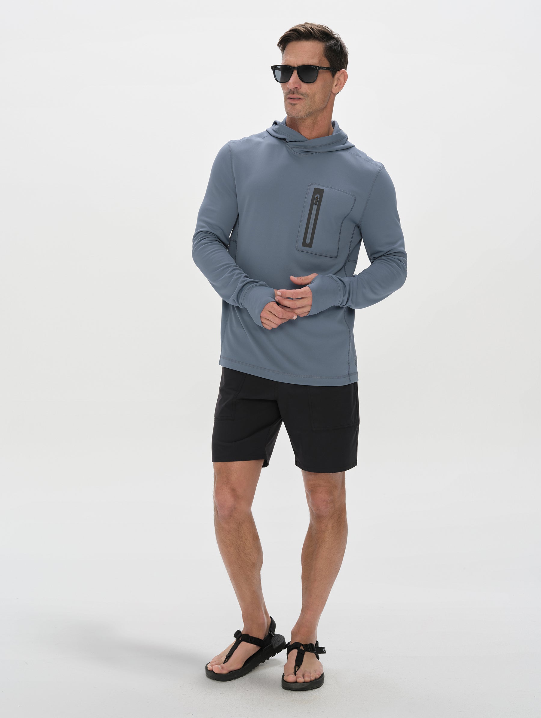 Front full-body view of man wearing Pacific Hooded Sun Shirt in Portal Blue from AETHER Apparel.