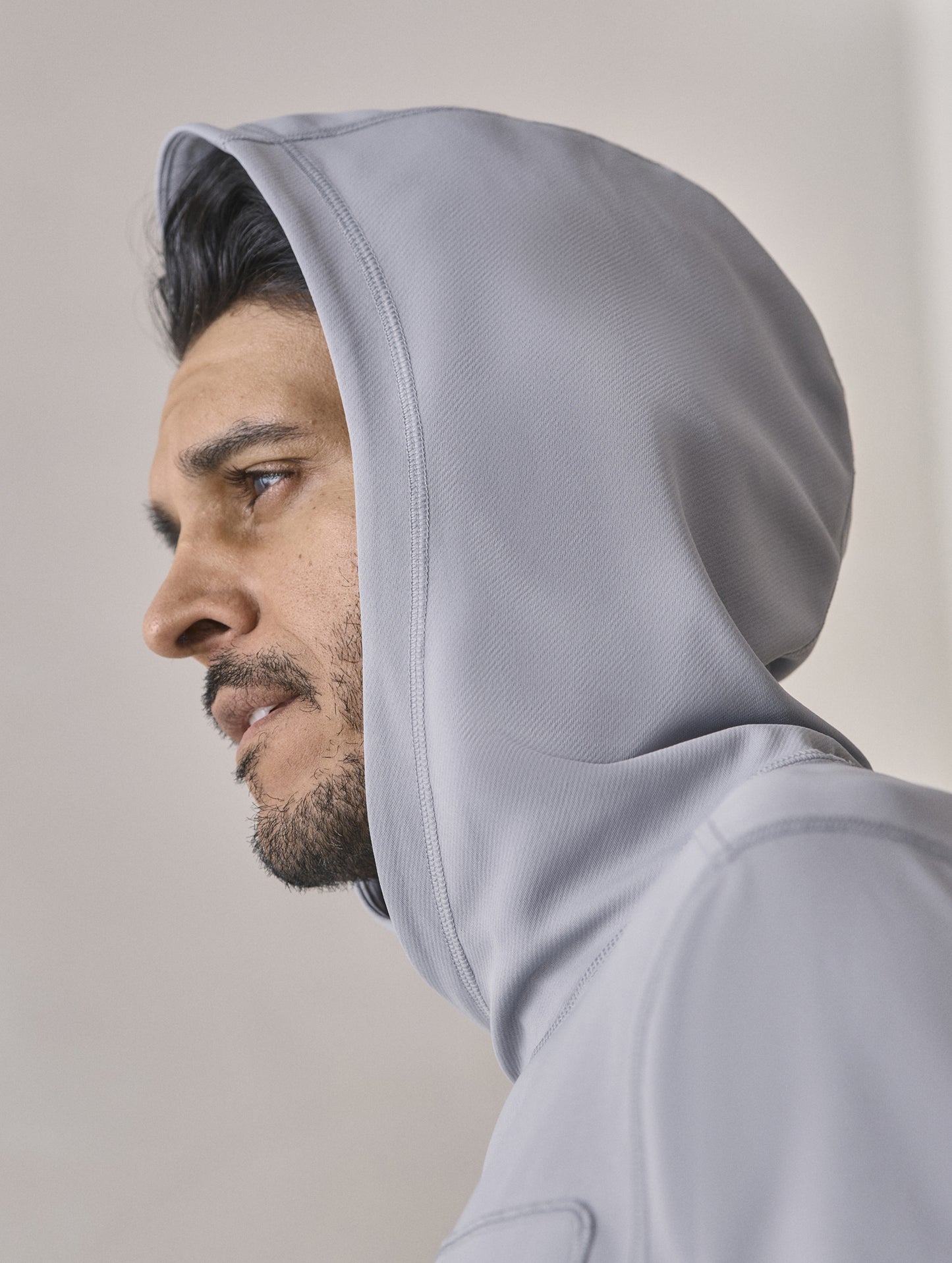 Closeup view of man with hood up wearing the Pacific Hooded Sun Shirt in Sky Grey from AETHER Apparel.
