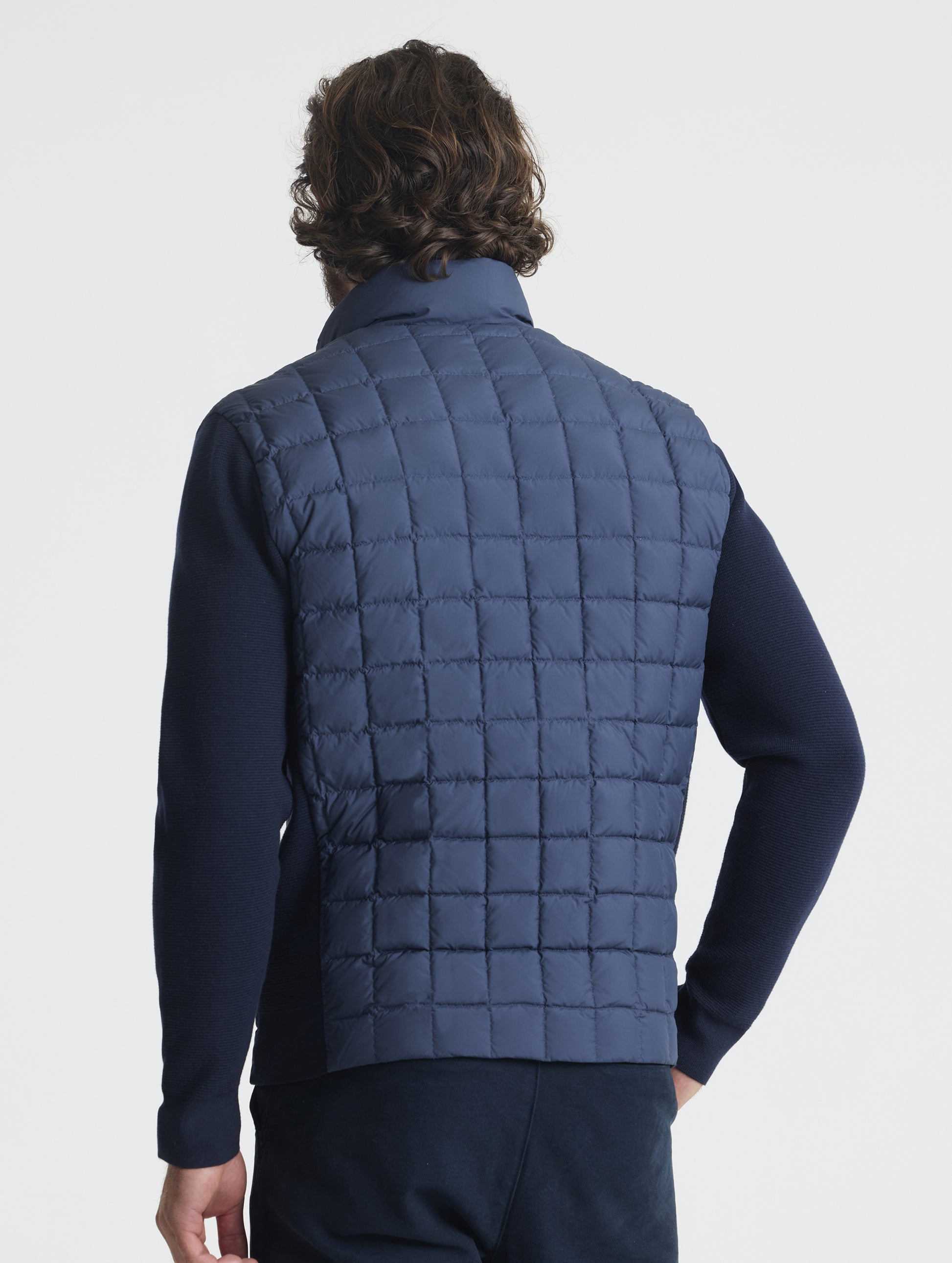 Rear, angled upper-body view of man wearing M Phase Full-Zip in Total Eclipse dark blue from AETHER Apparel.