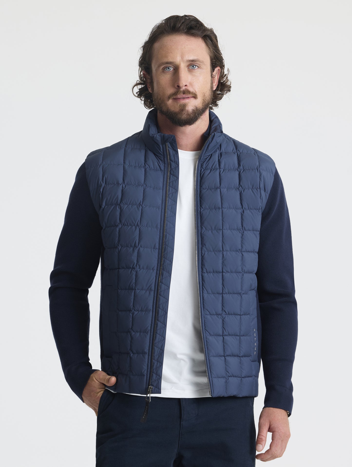 Front upper-body view of man wearing unzipped M Phase Full-Zip in Total Eclipse dark blue from AETHER Apparel.