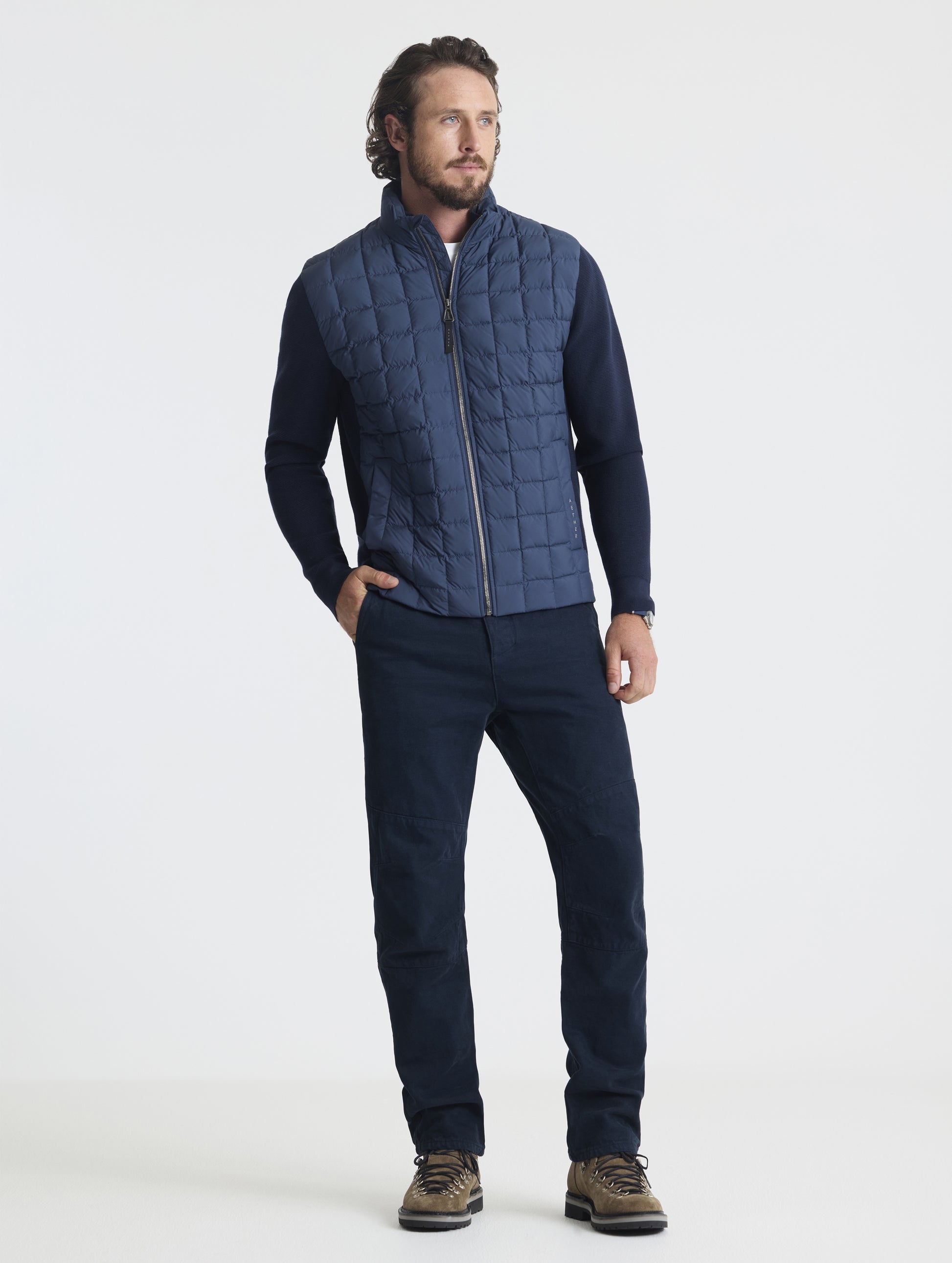 Front full-body view of man wearing zipped-up M Phase Full-Zip in Total Eclipse dark blue from AETHER Apparel.