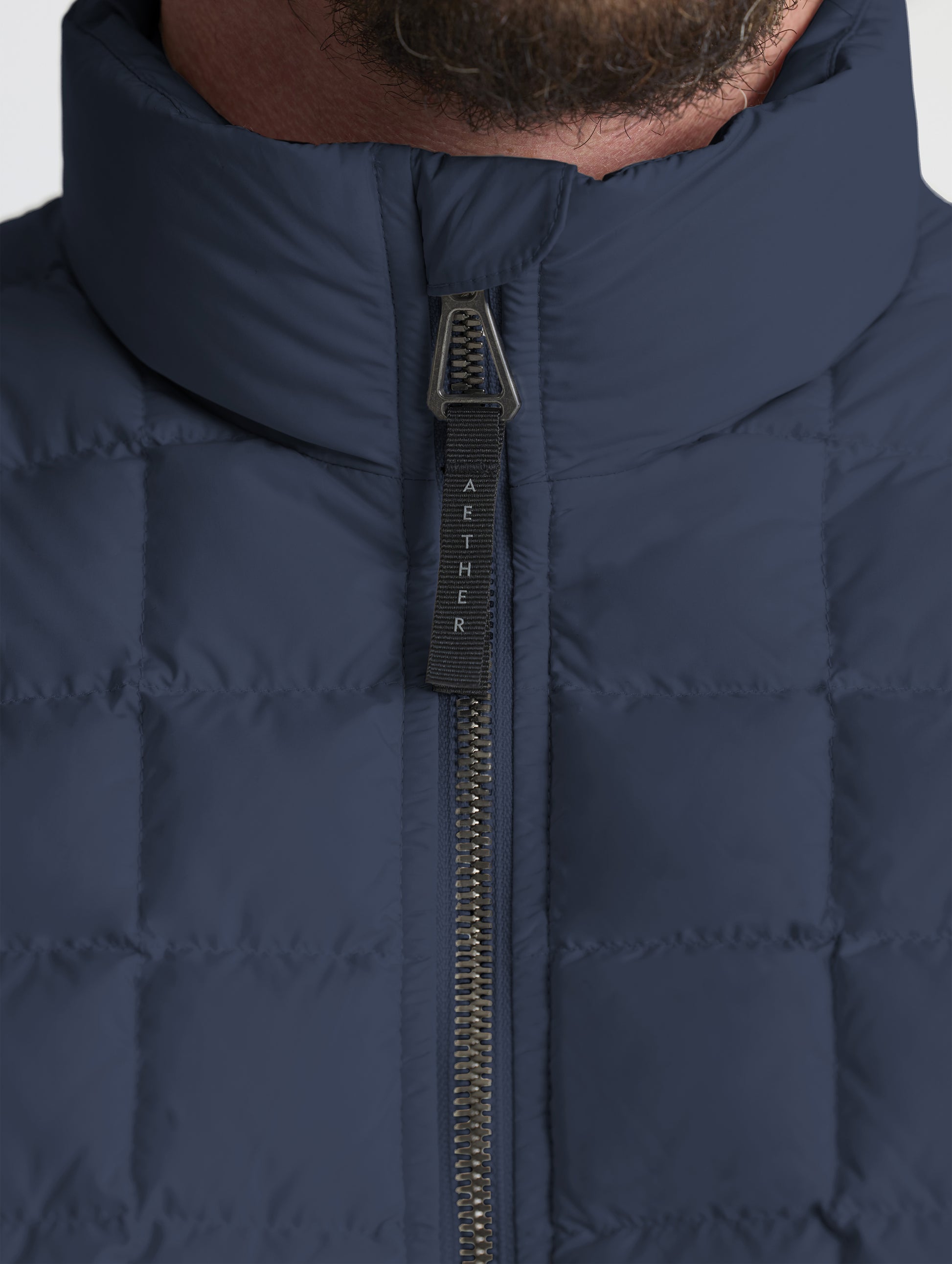 Closeup detailed view of the main center-front zipper on the M Phase Full-Zip in Total Eclipse dark blue from AETHER Apparel.