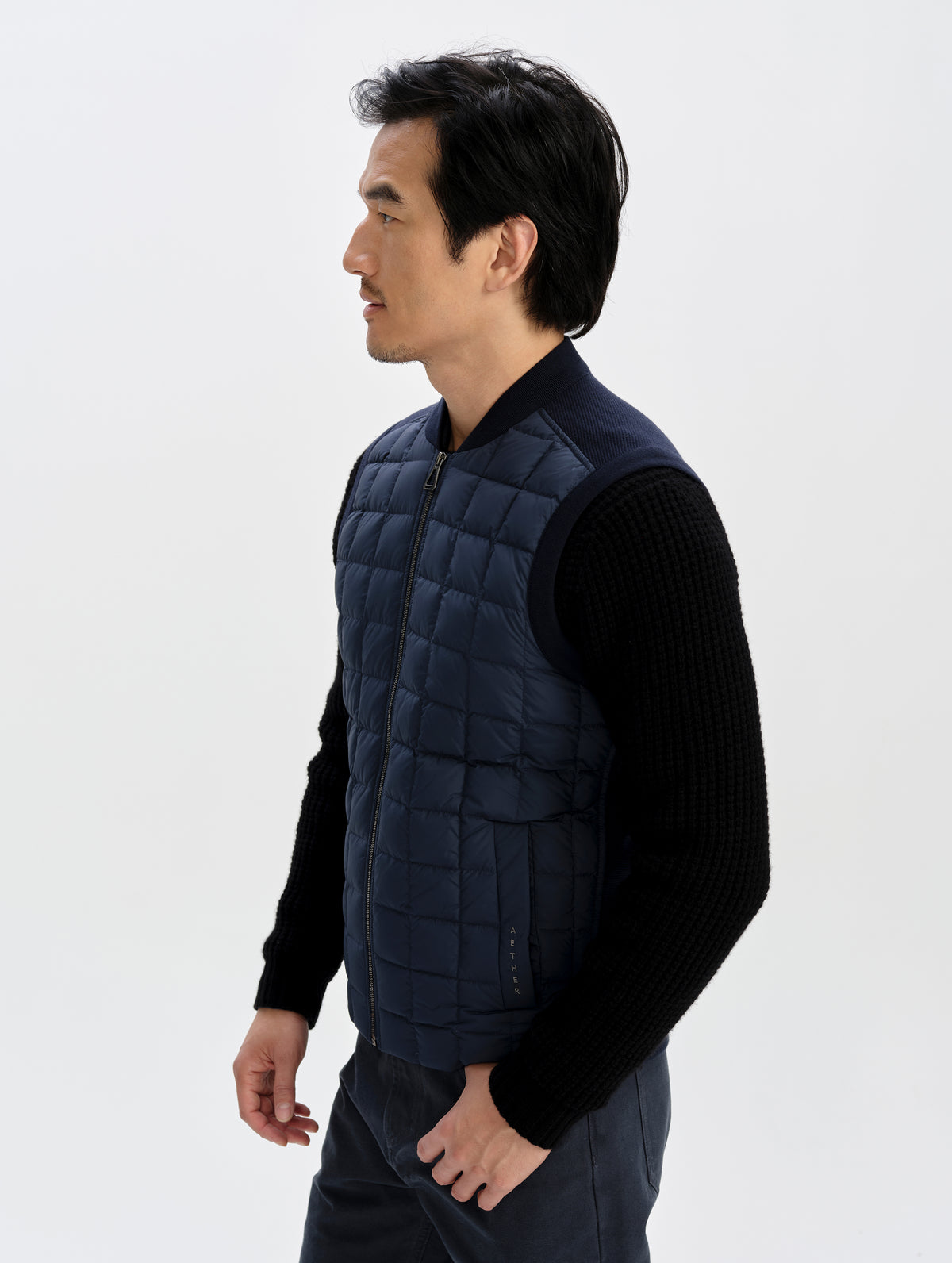 Front 3/4 upper-body view of man wearing the M Phase Vest in Total Eclipse from AETHER Apparel. 