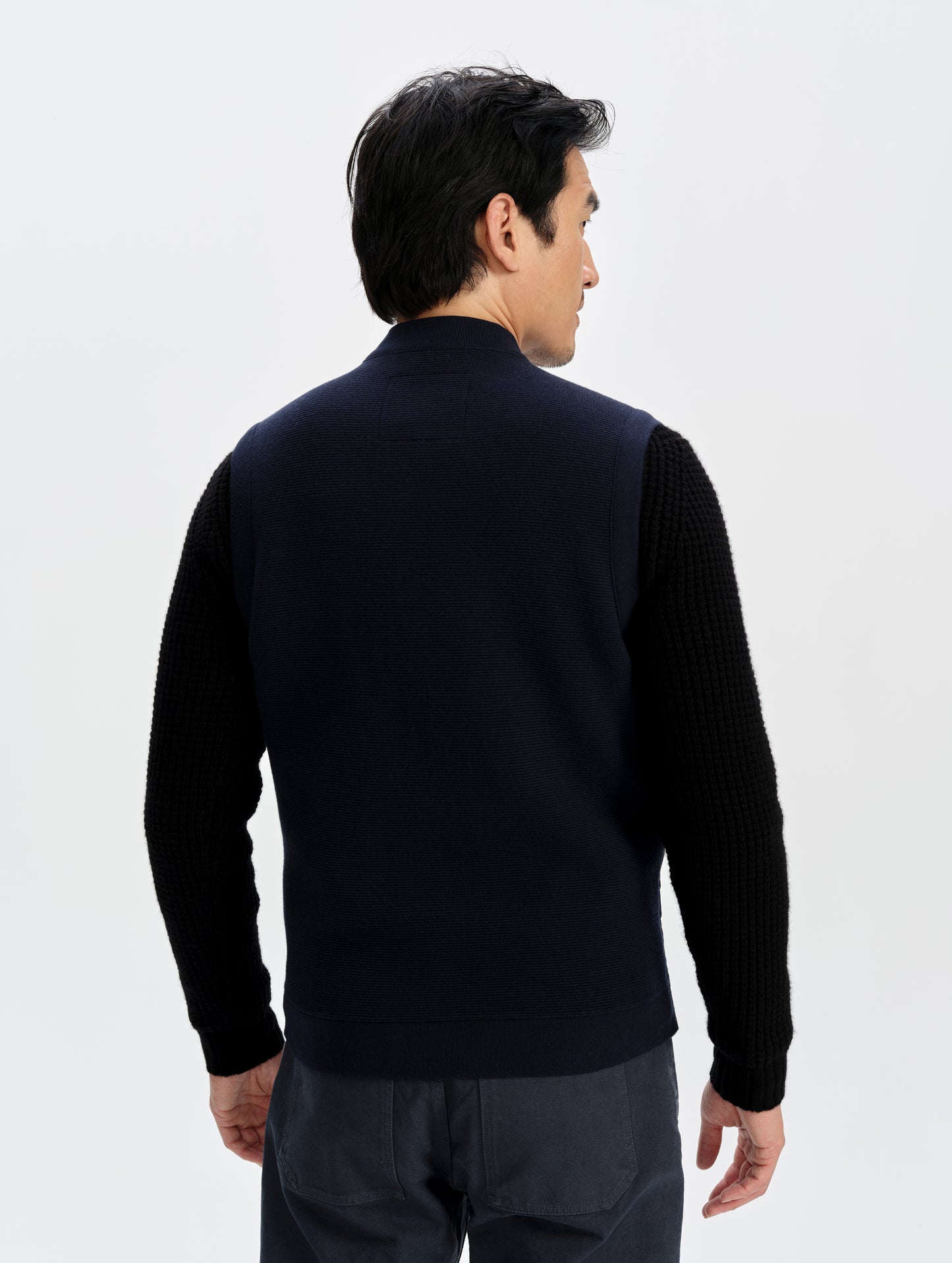 Rear upper-body view of man wearing the M Phase Vest in Total Eclipse from AETHER Apparel. 